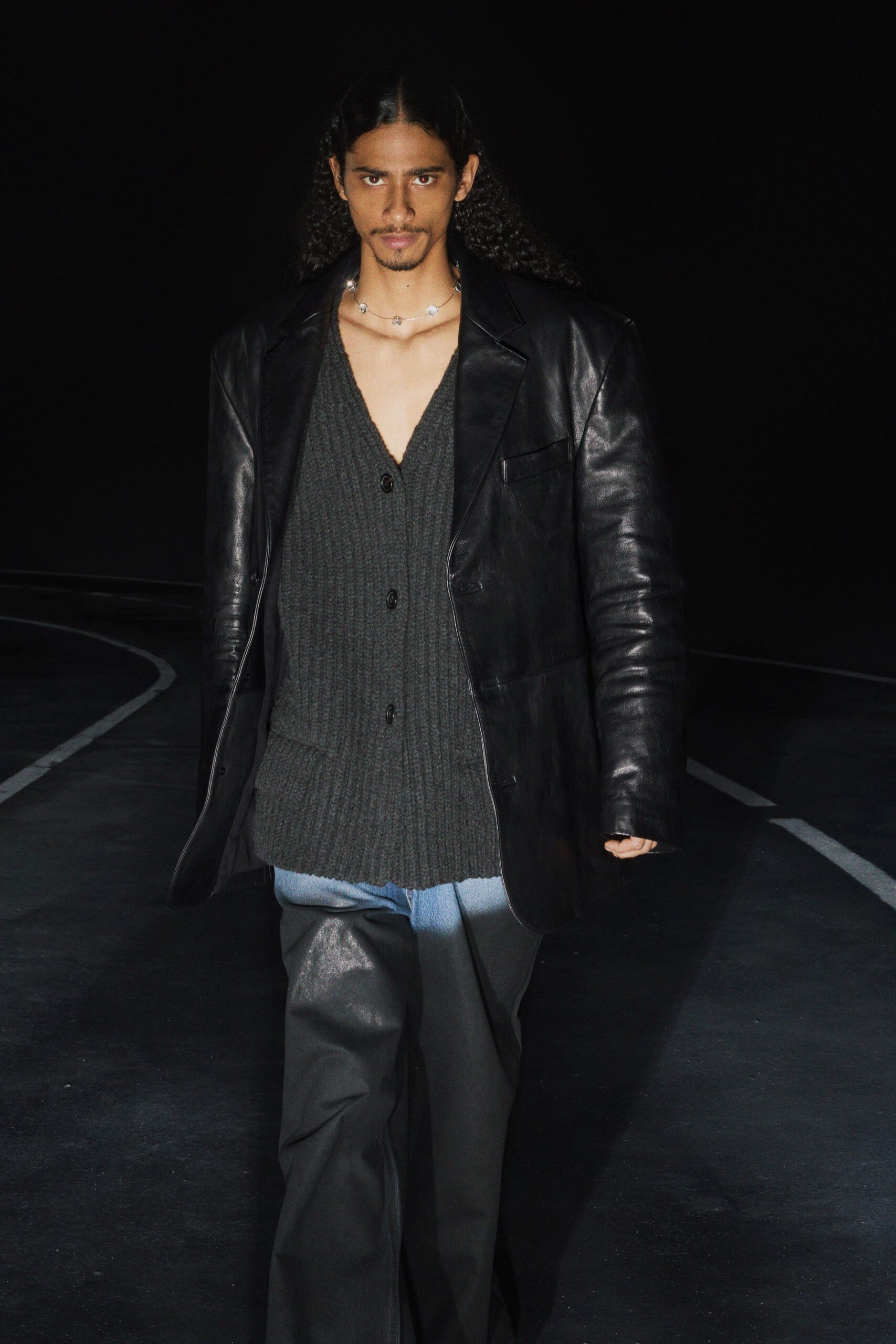 black leather jacket gray sweater blue pants