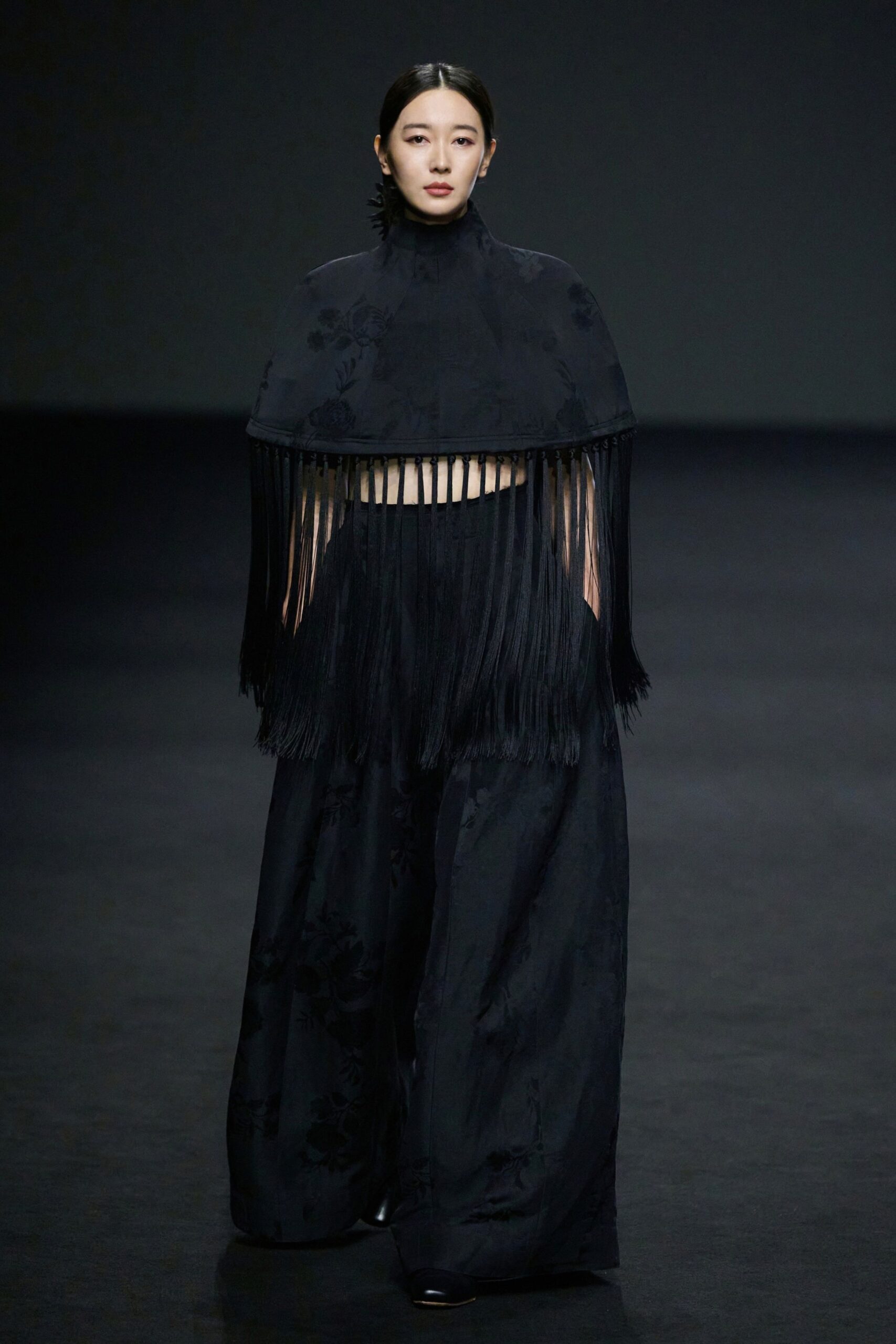 black silk cape and wide-leg pants