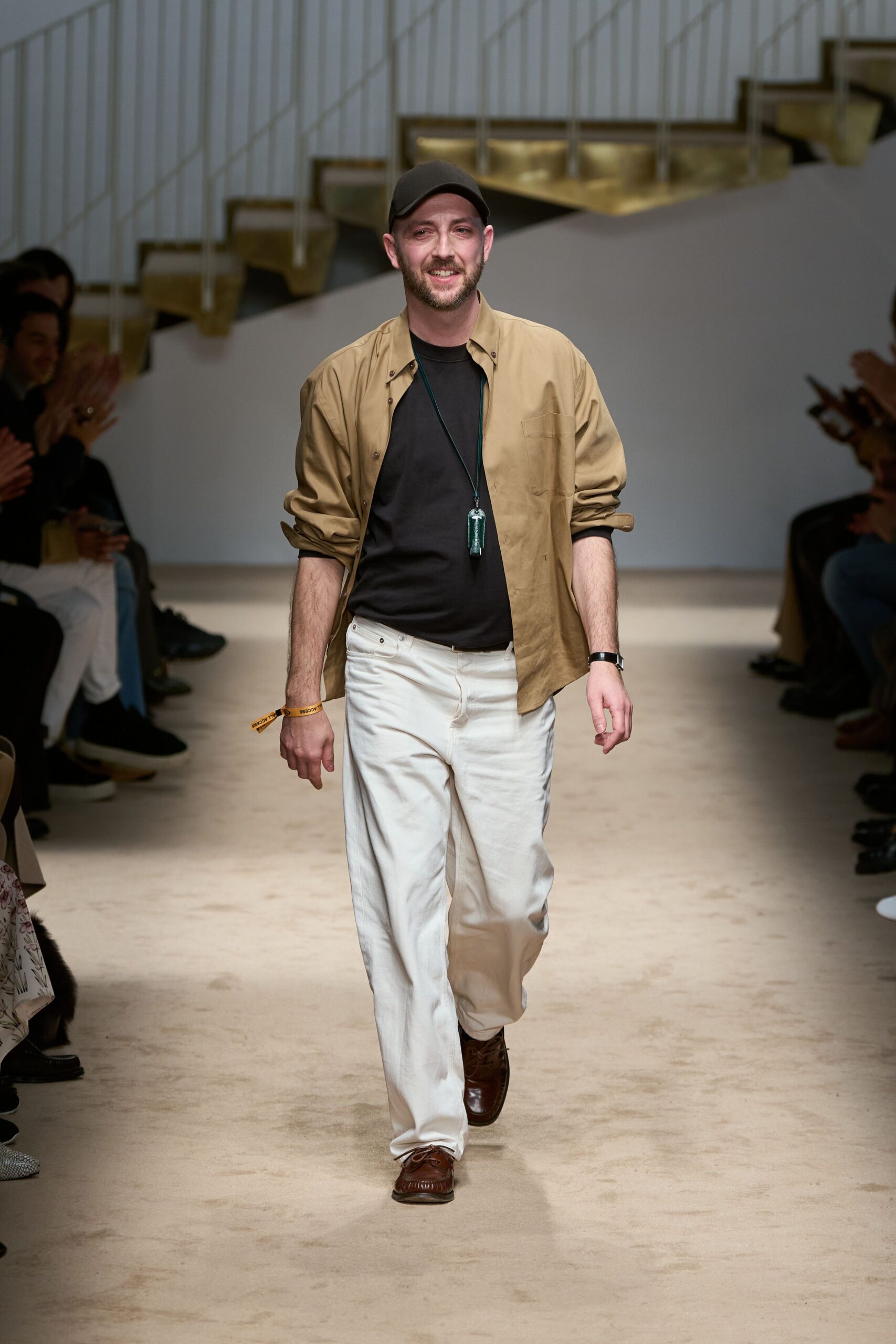 beige jacket black t-shirt white pants