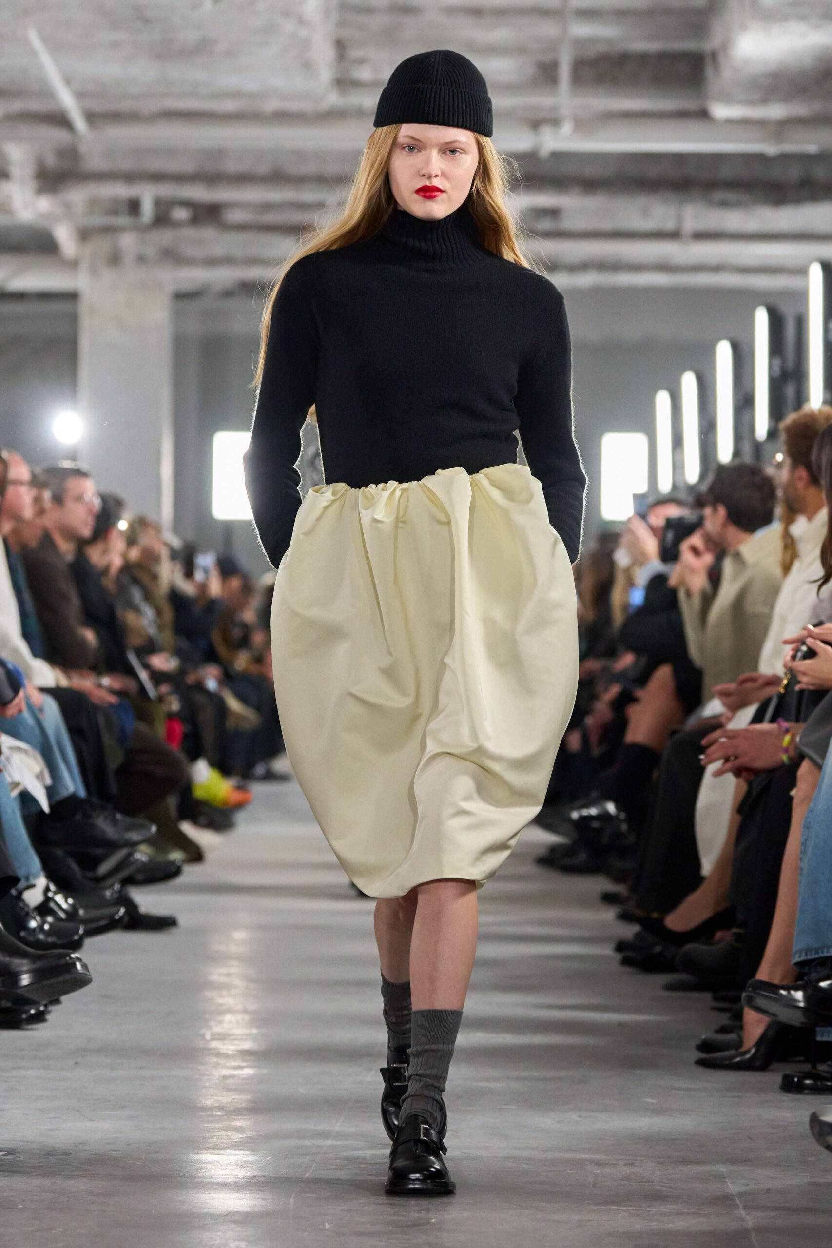 black fitted turtleneck top with white pleated skirt
