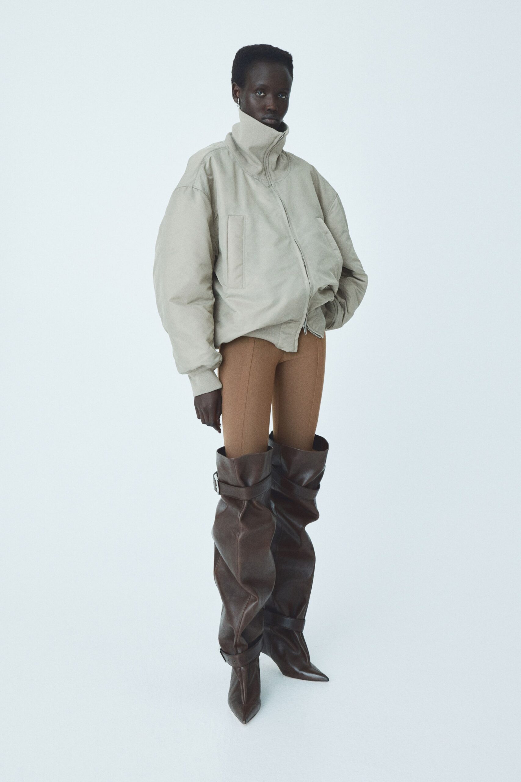 beige relaxed jacket with brown fitted pants and boots