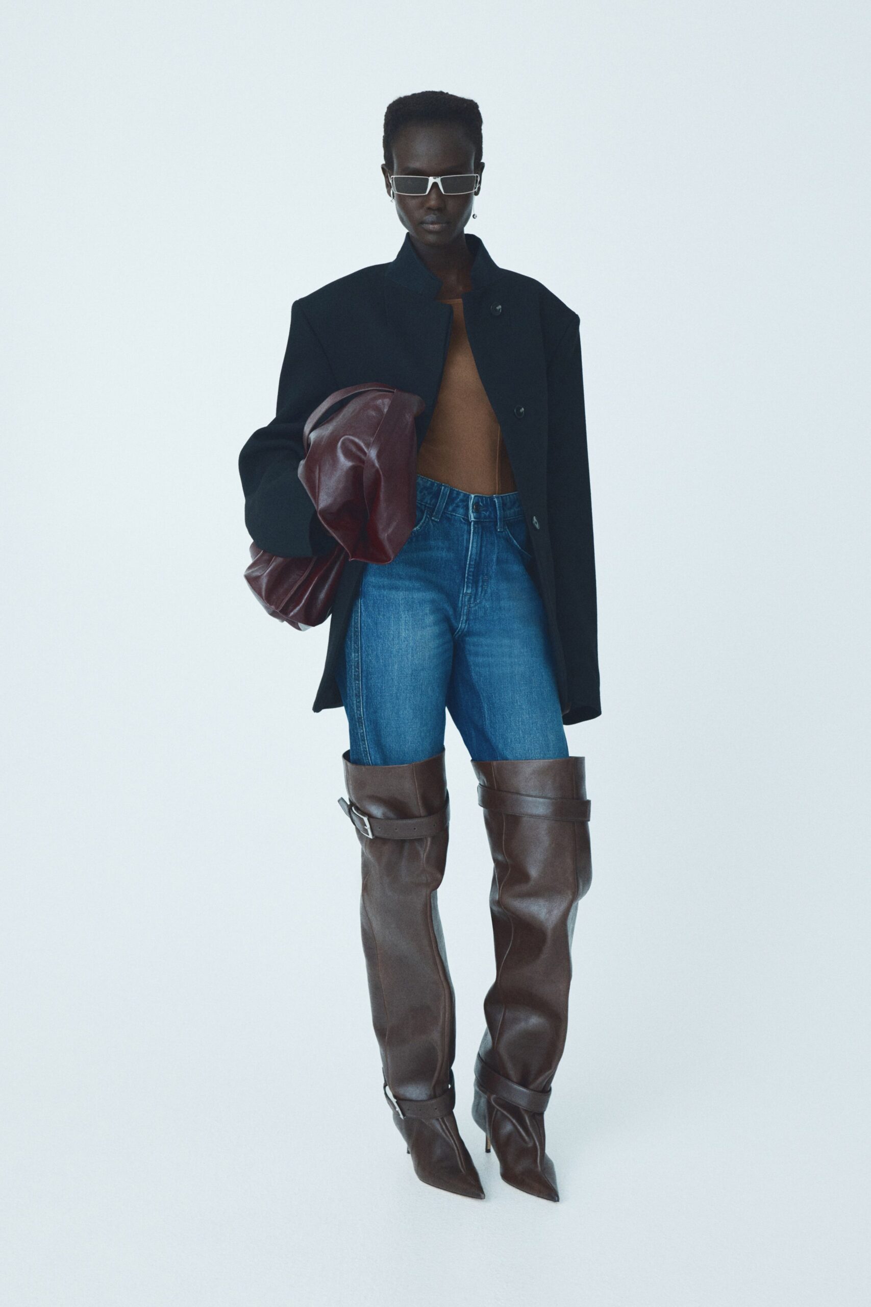 black coat brown top blue jeans