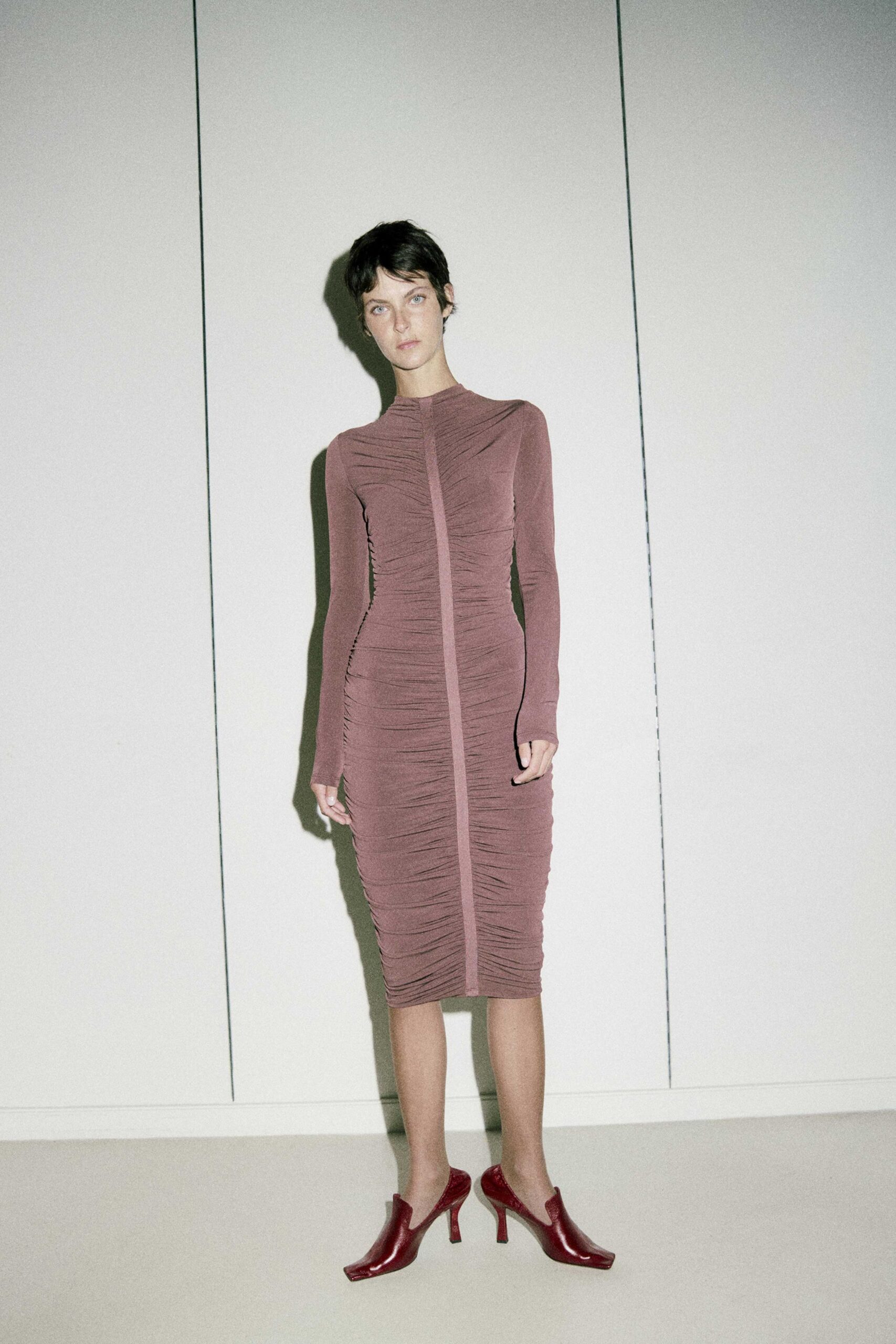 fitted pink ruched midi dress with red heels