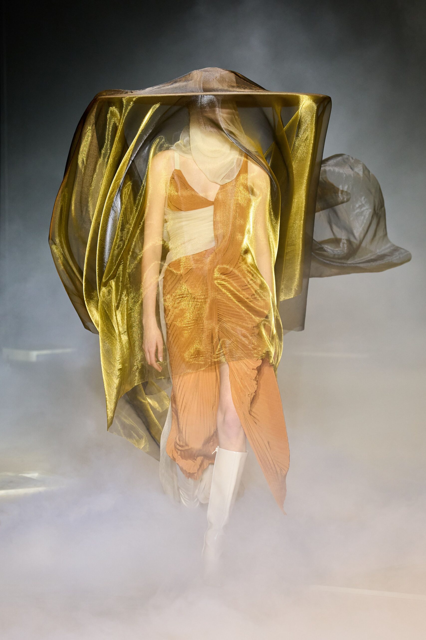 gold and orange pleated dress with cape