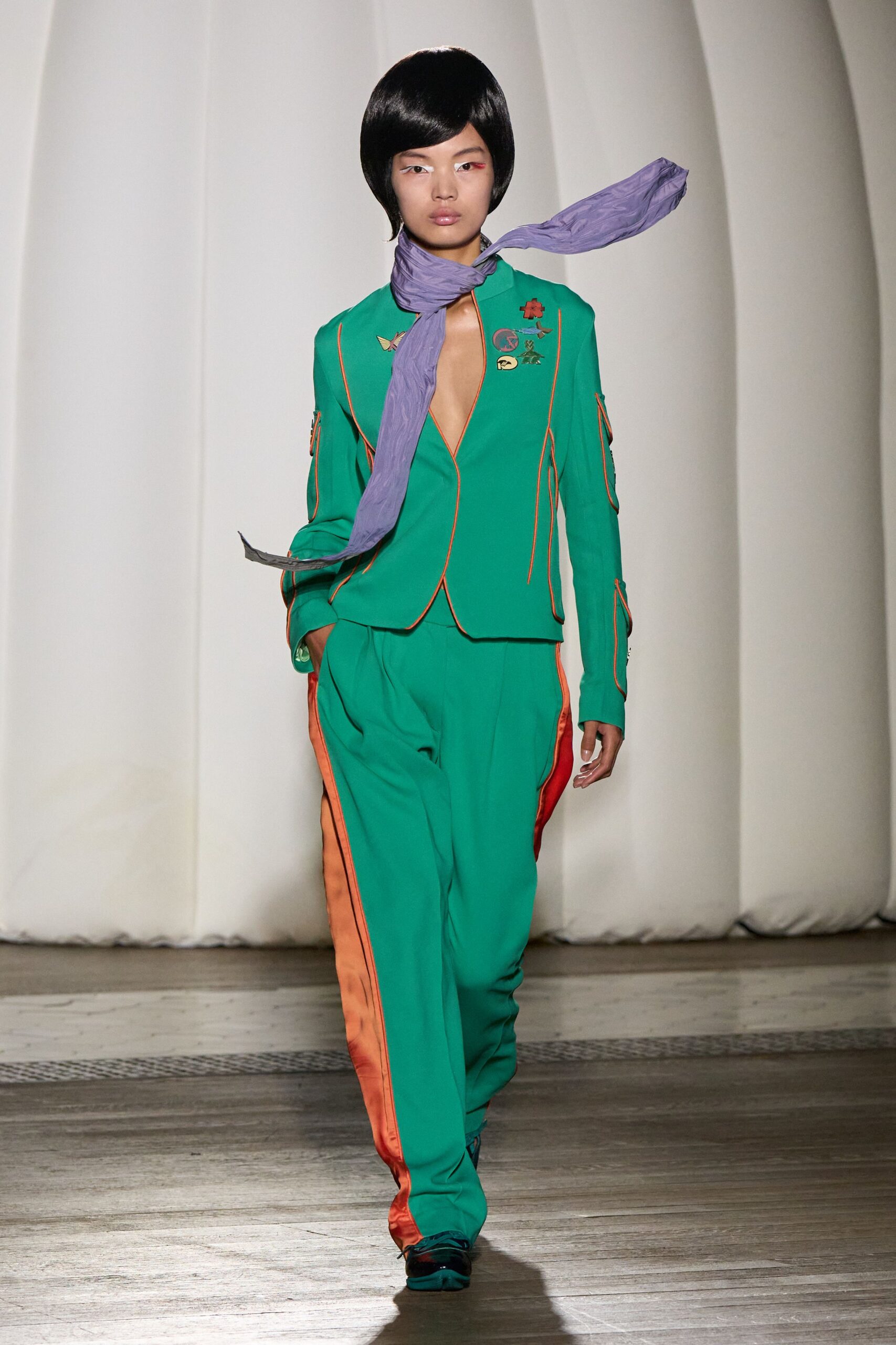 green fitted suit with purple scarf