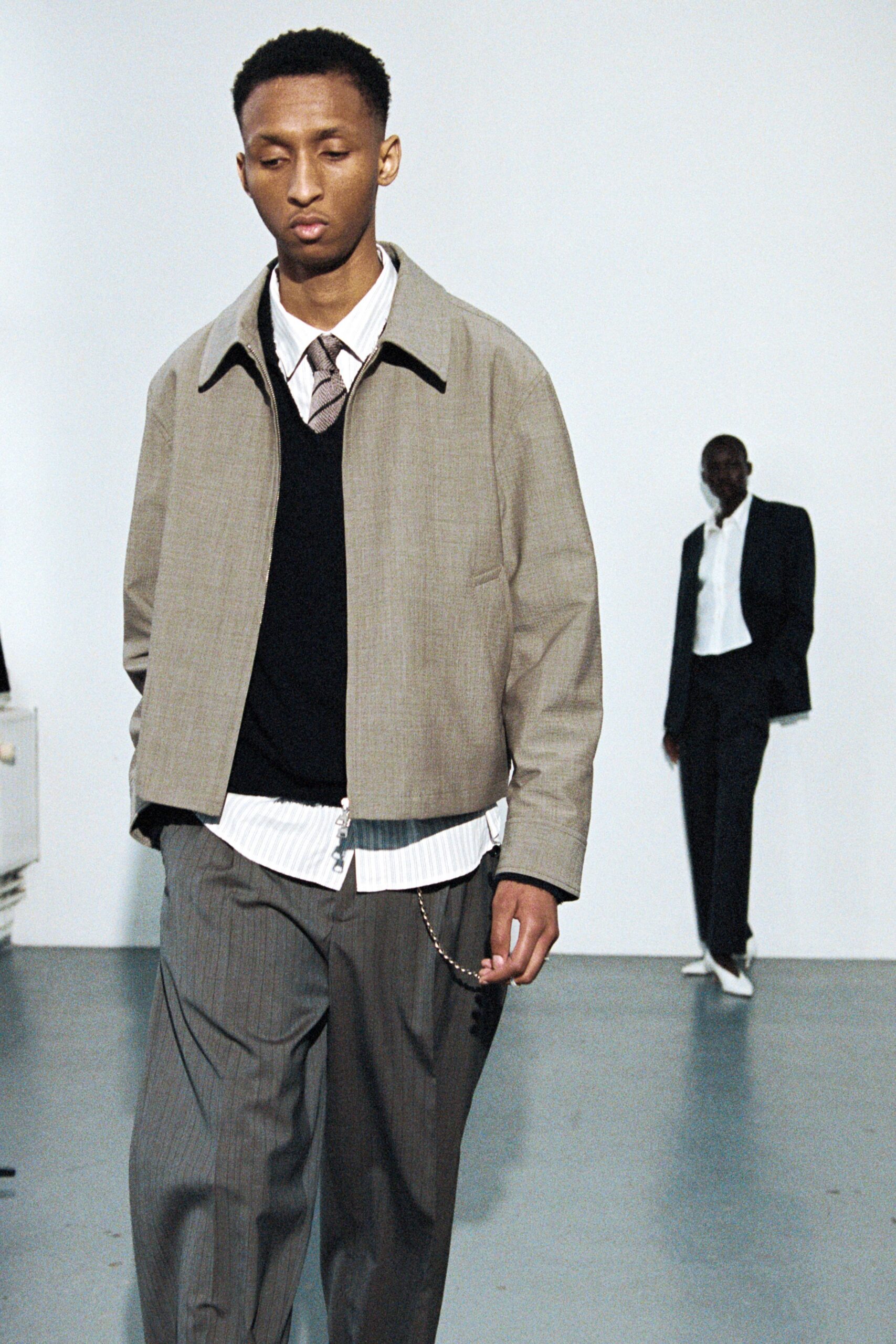 beige jacket black sweater gray pants