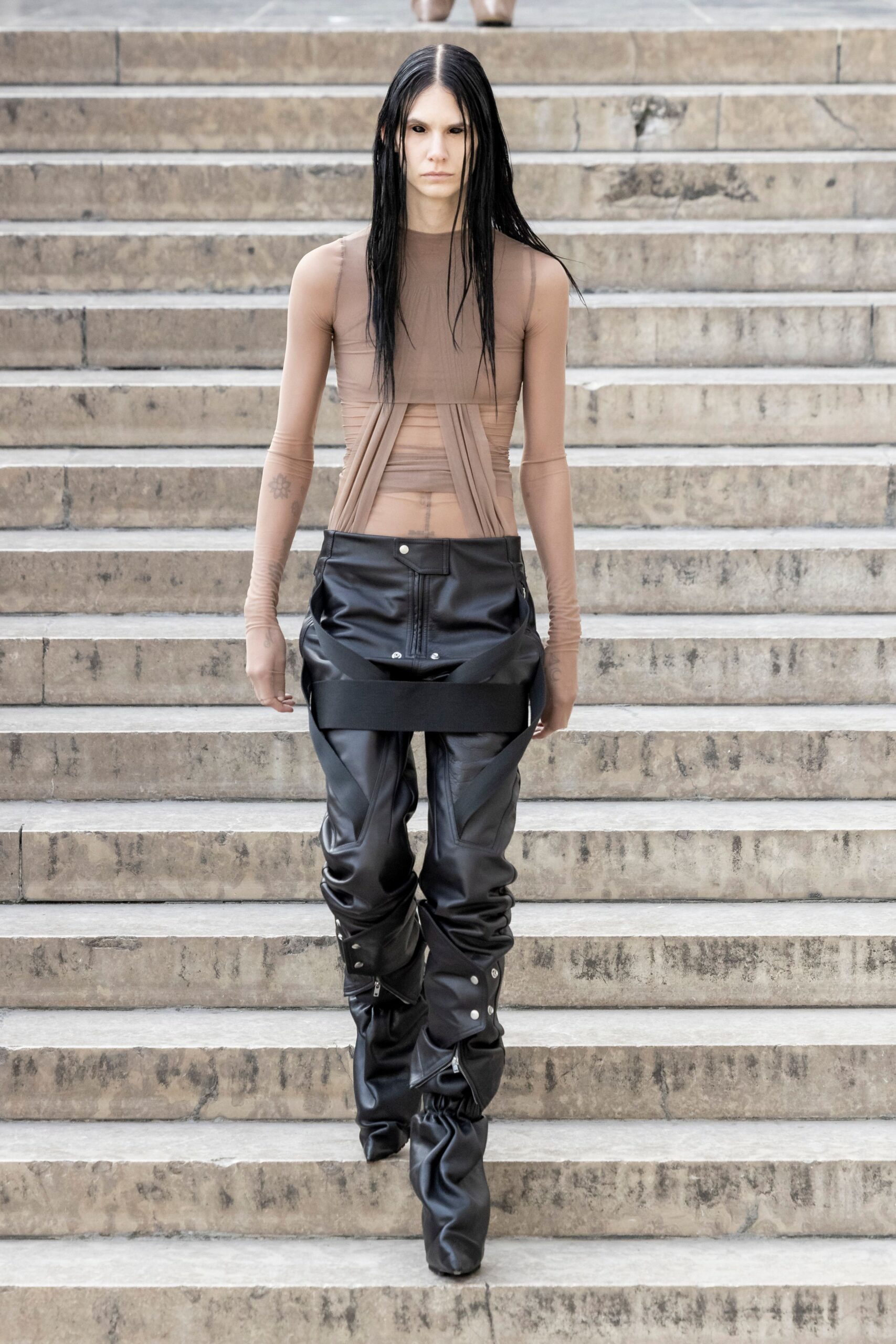 beige mesh fitted top and black leather pants