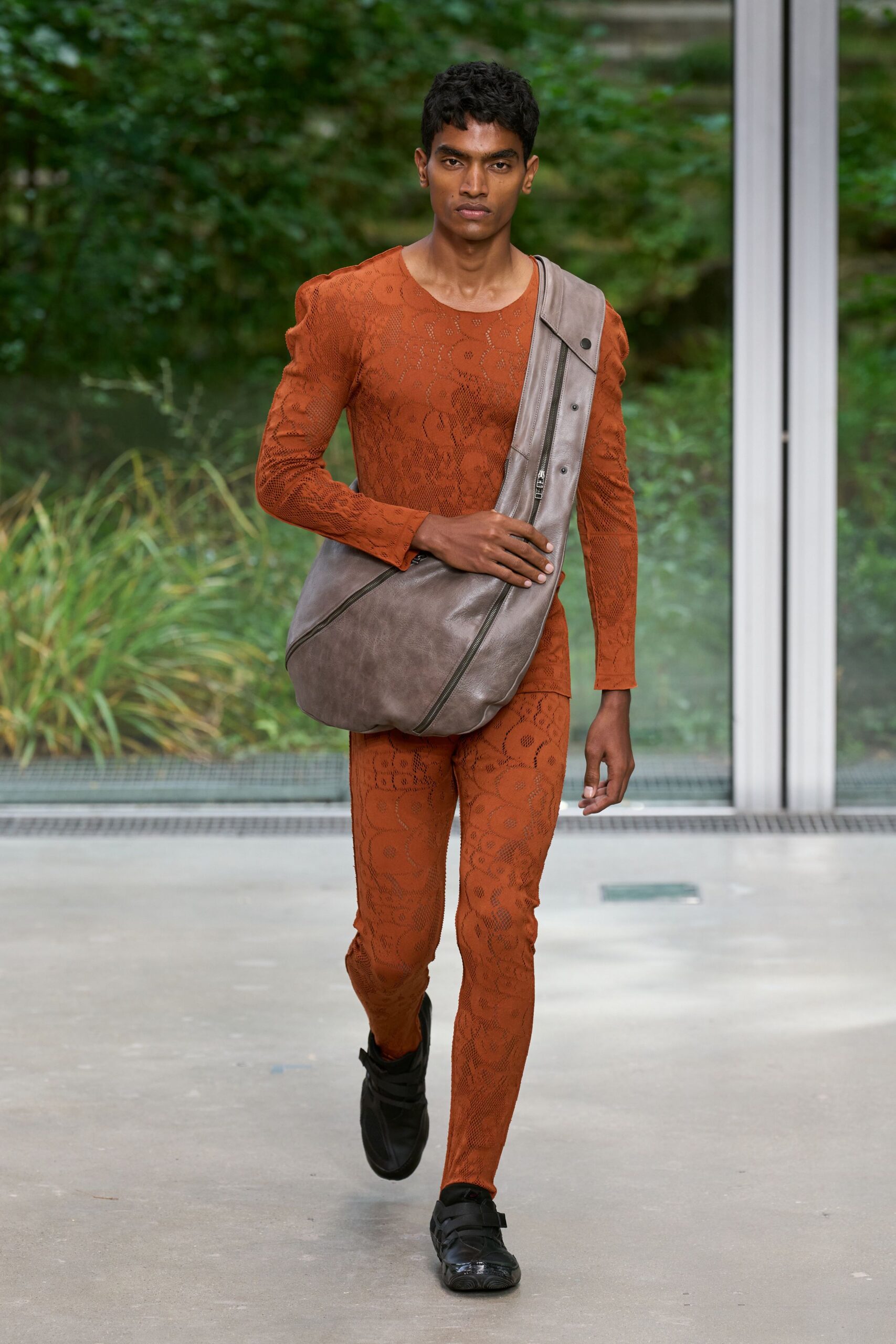 orange fitted catsuit with black shoes