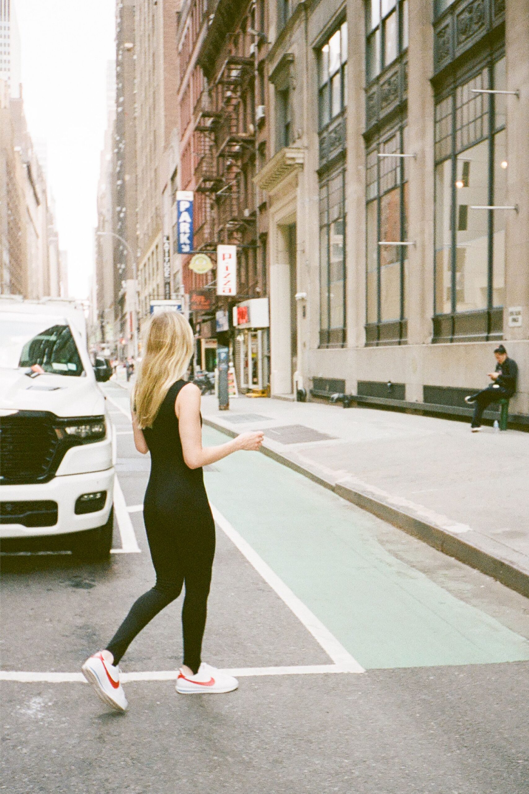 black fitted sleeveless catsuit with sneakers