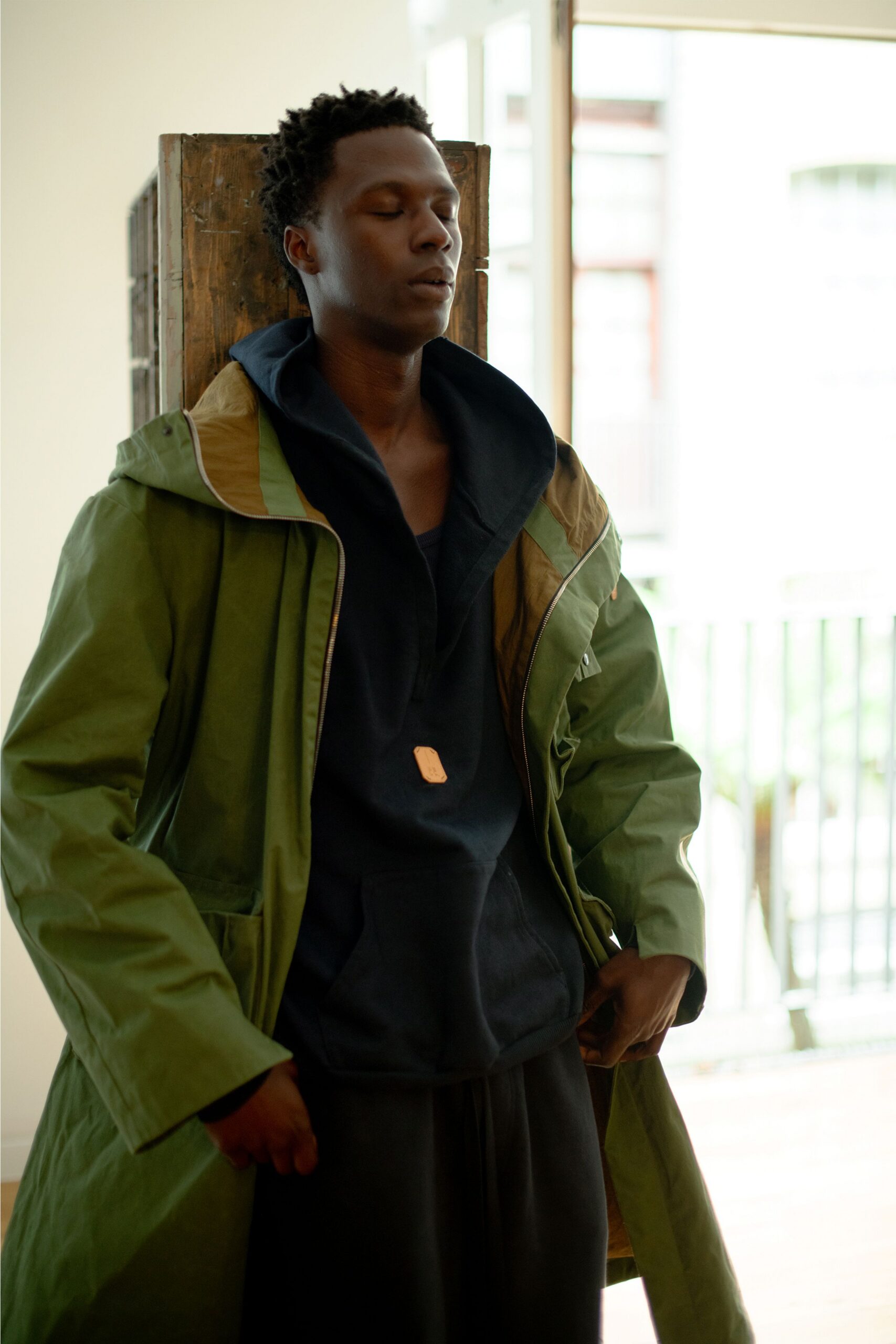 green coat black hoodie black pants