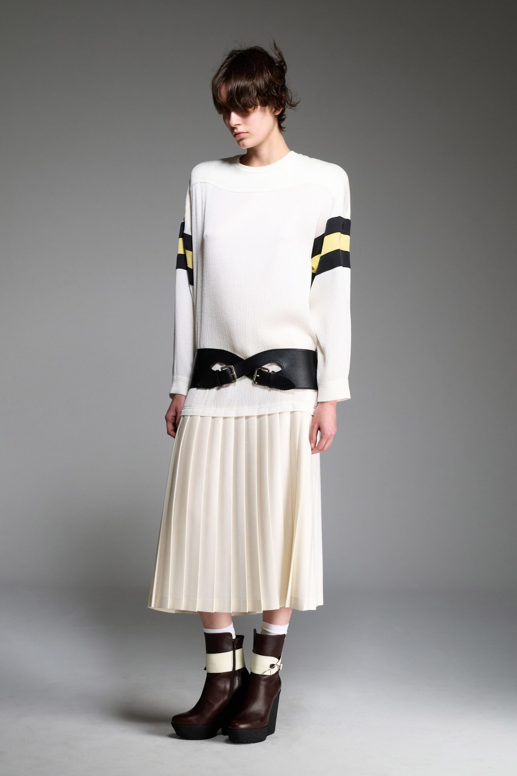 white relaxed top with beige pleated skirt