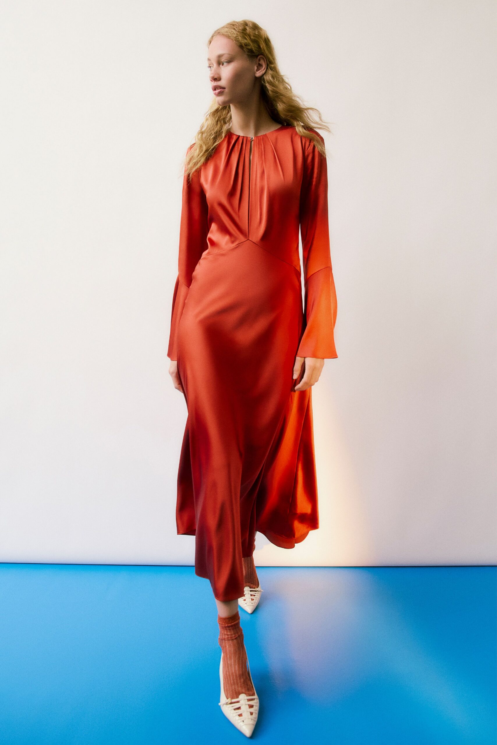 orange silk long-sleeve v-neck fitted pleated flowing gown
