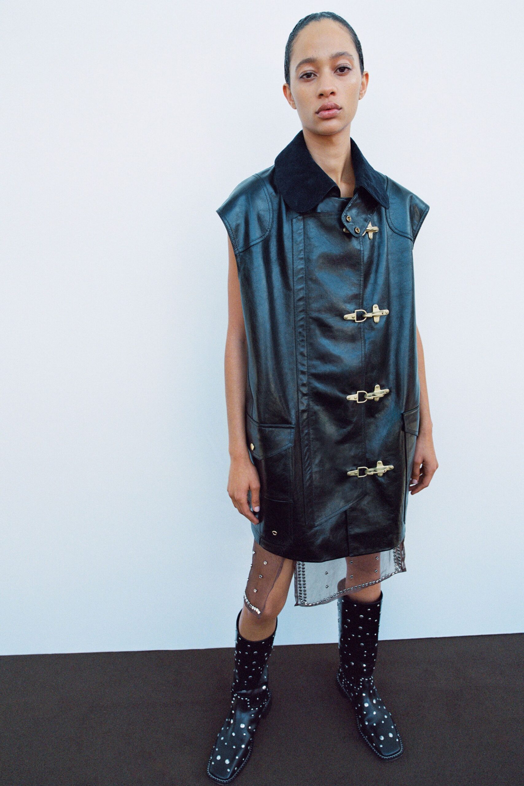 black leather sleeveless coat and boots