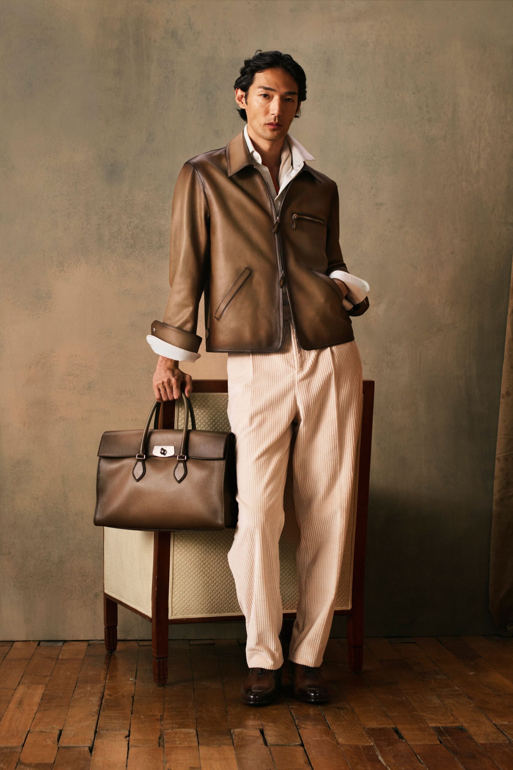 brown leather jacket and beige pants