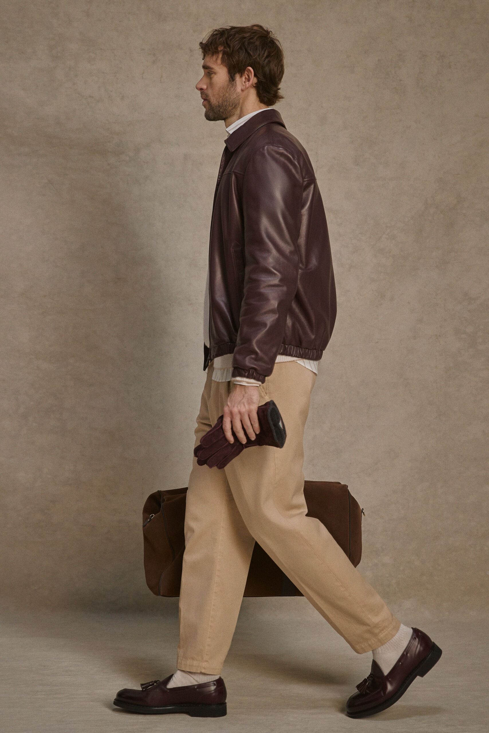 brown leather jacket and beige pants