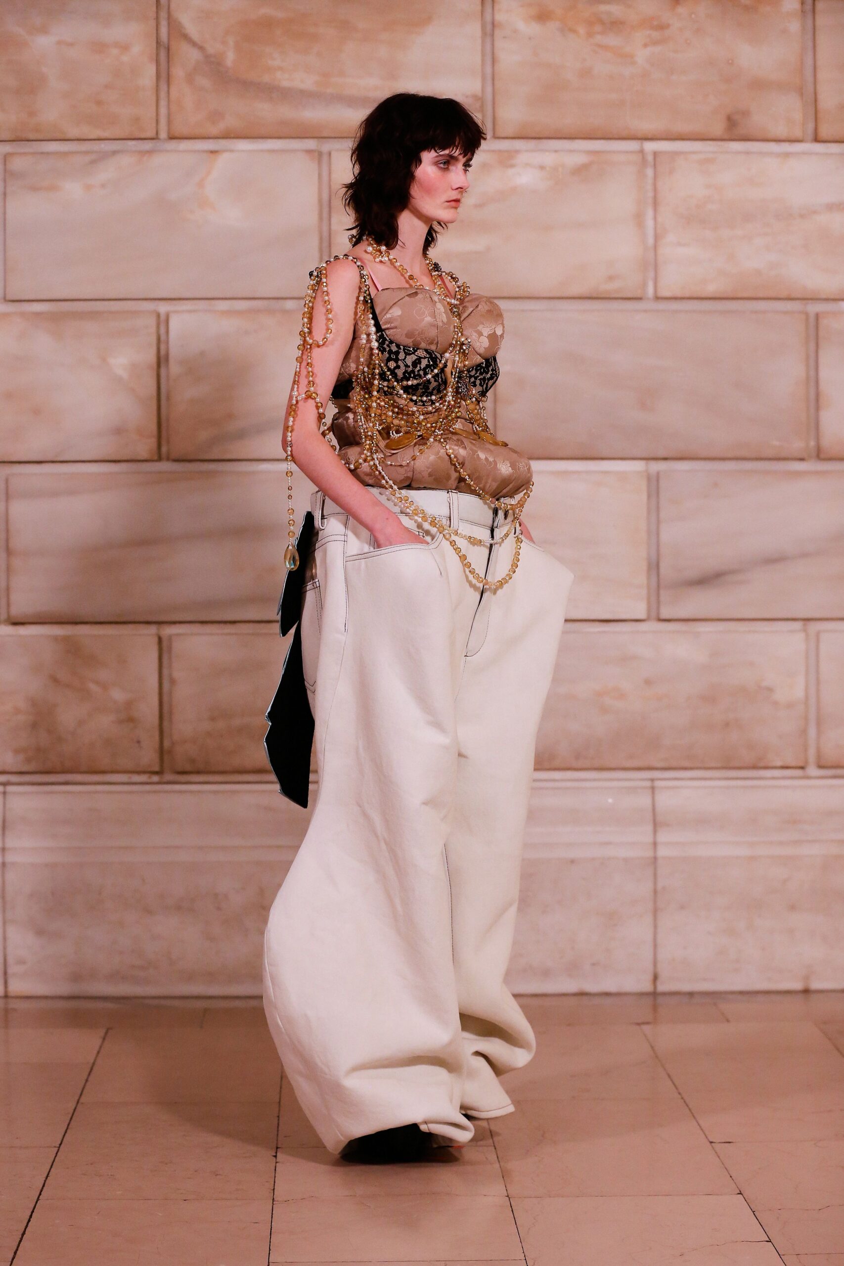 black and beige layered top with white wide-leg pants