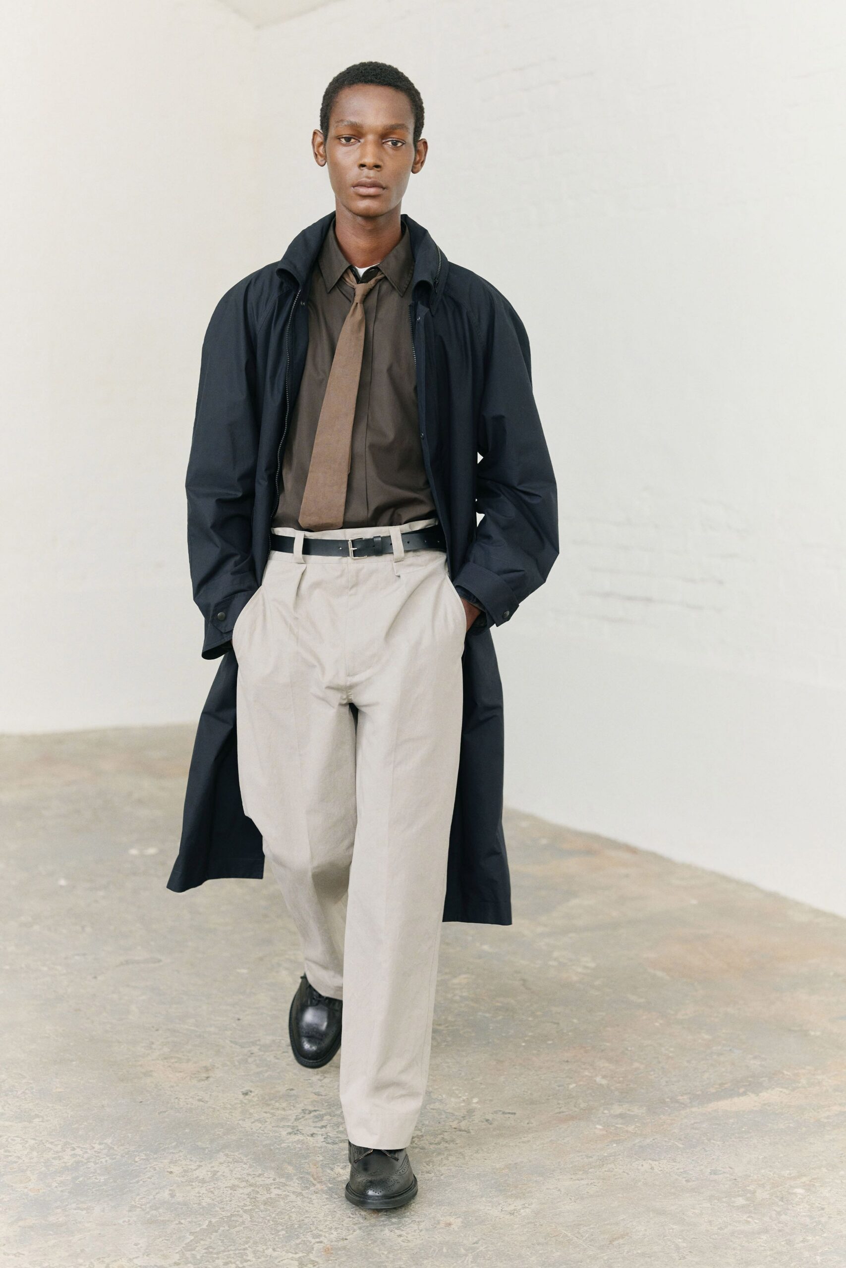 black coat brown shirt beige pants
