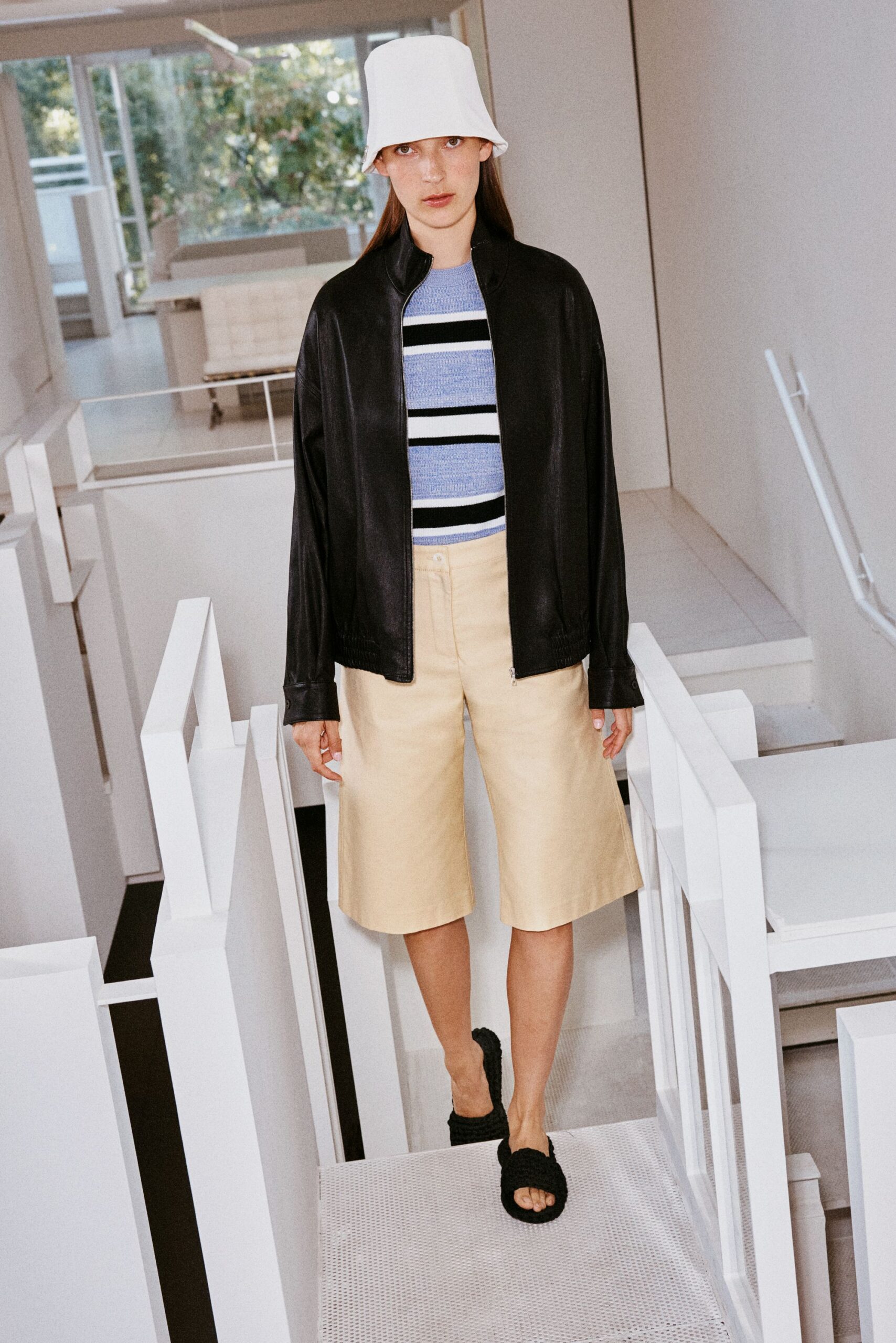 black leather jacket with beige shorts