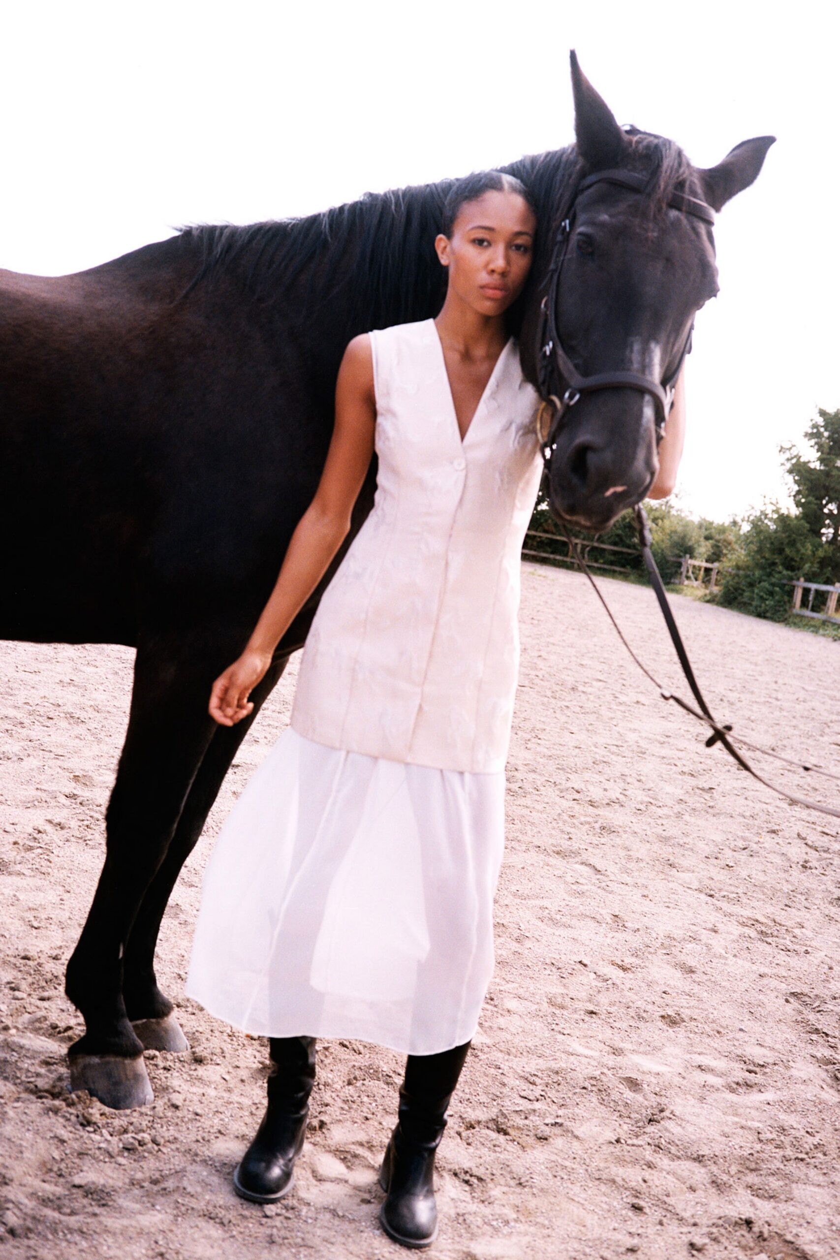 white silk sleeveless dress with black boots