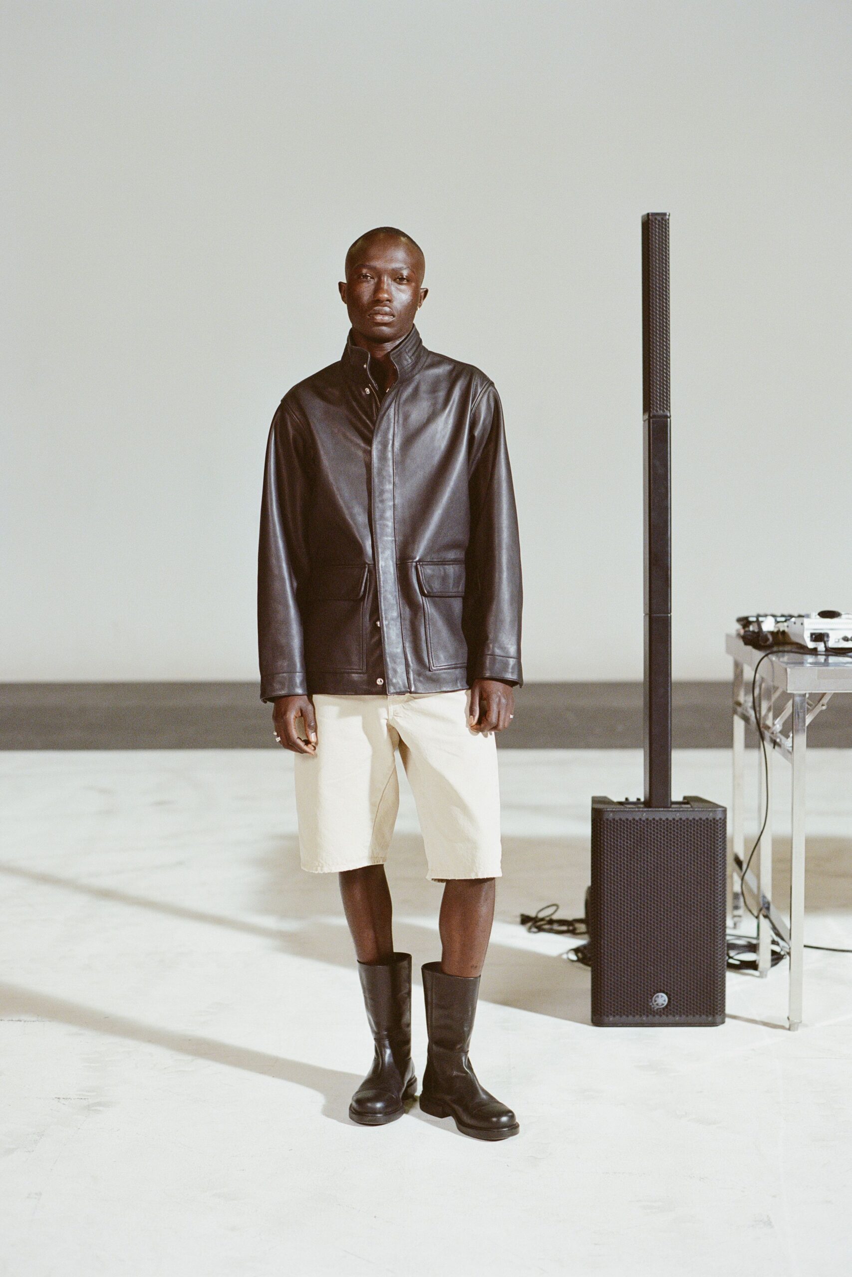 black leather jacket with beige shorts