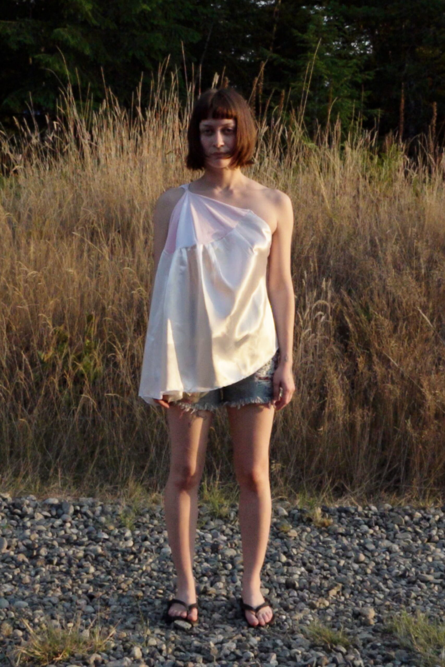 pink silk asymmetric top with denim shorts