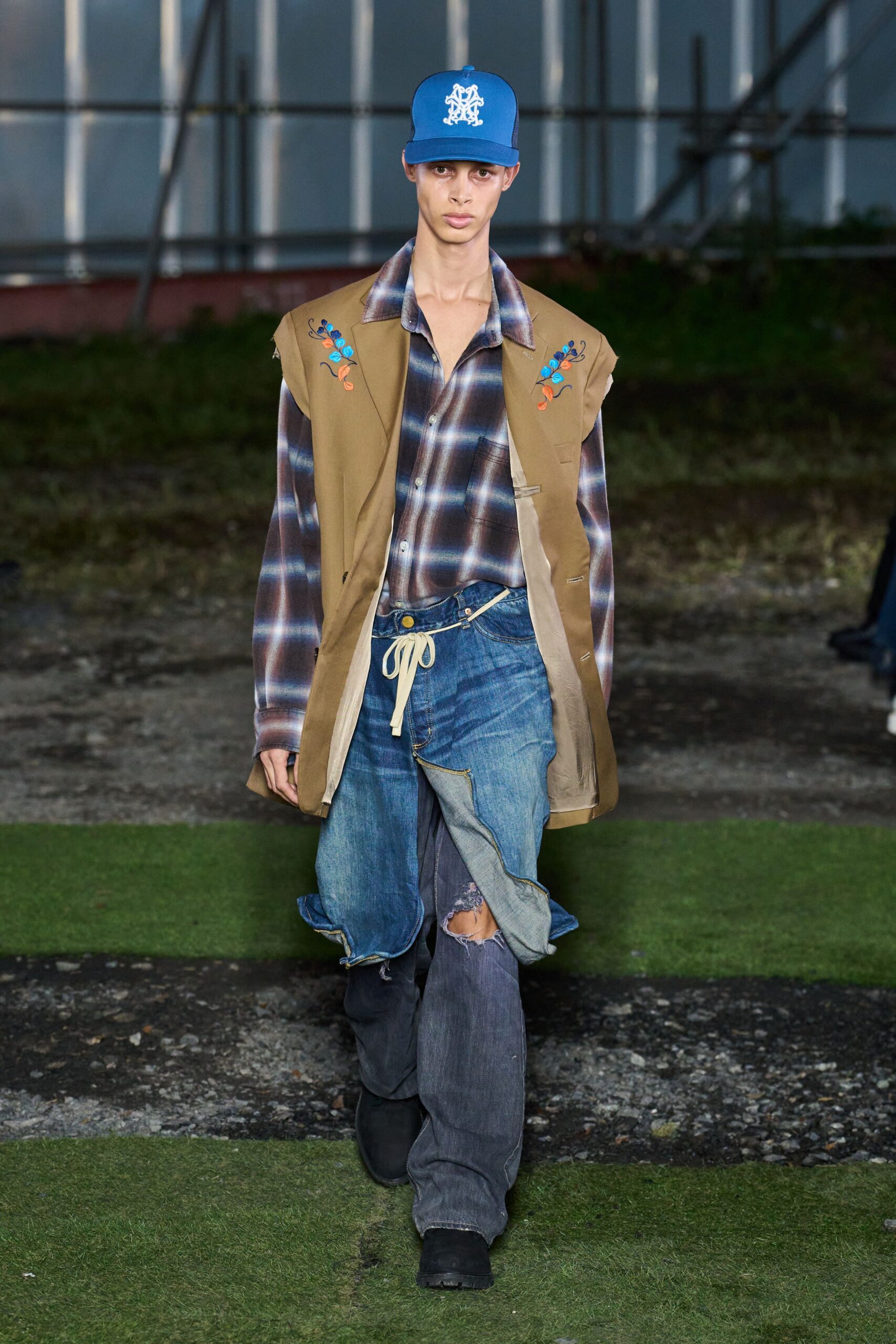 beige vest blue shirt distressed jeans