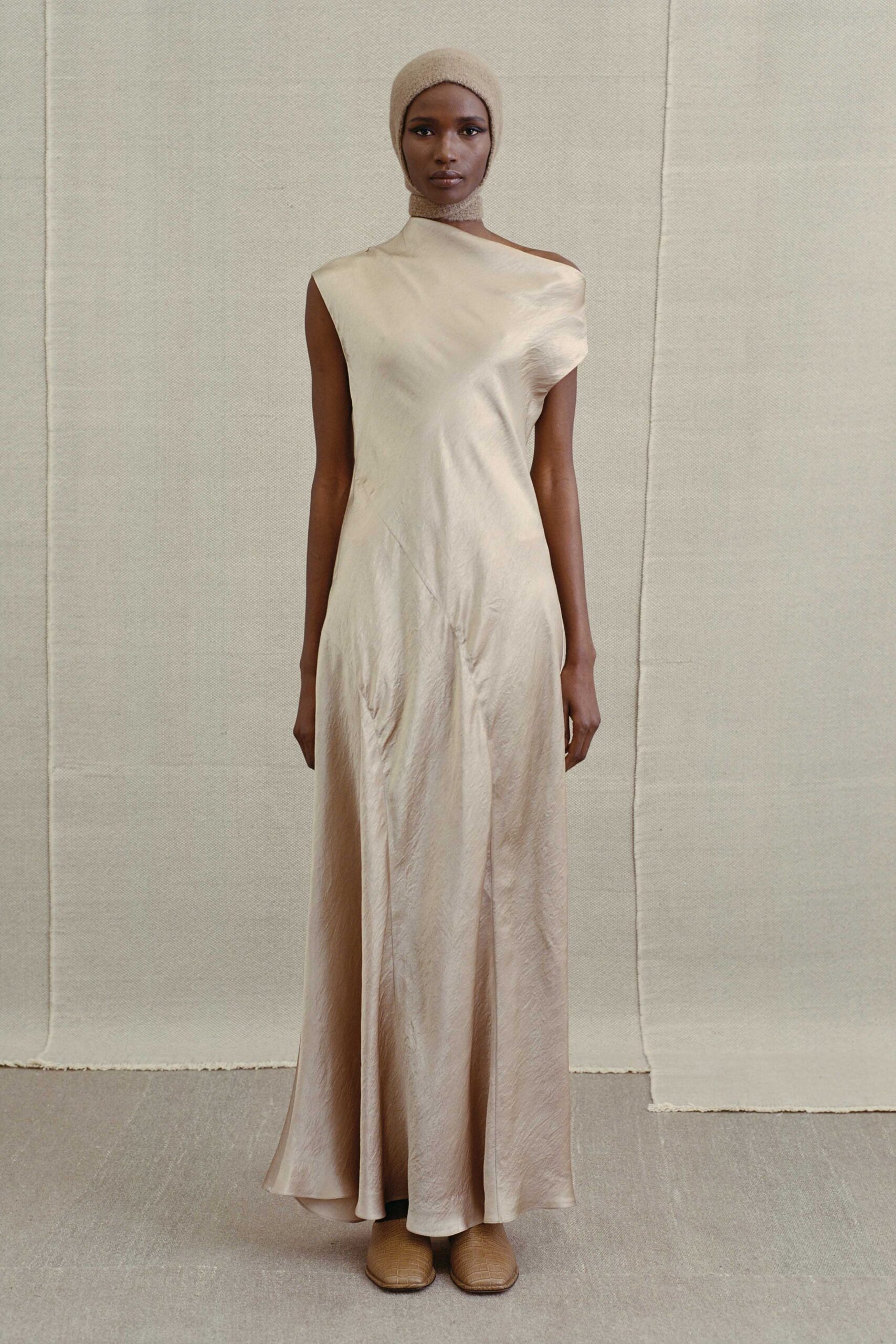 beige silk sleeveless high-neck fitted draped flowing gown
