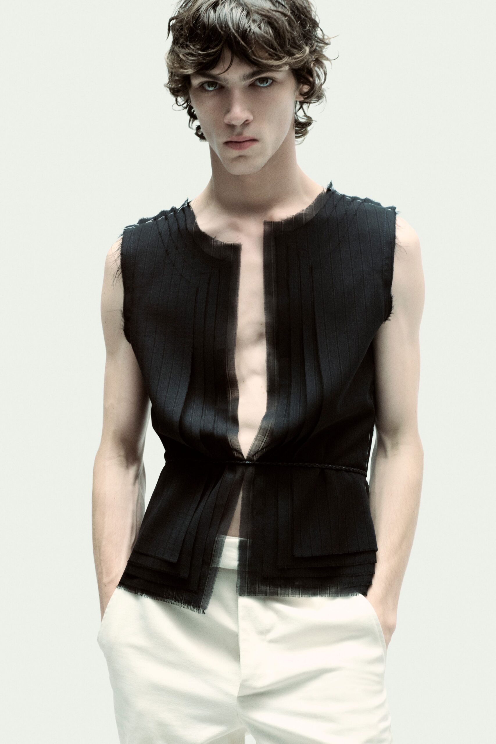 black pleated sleeveless top and white pants