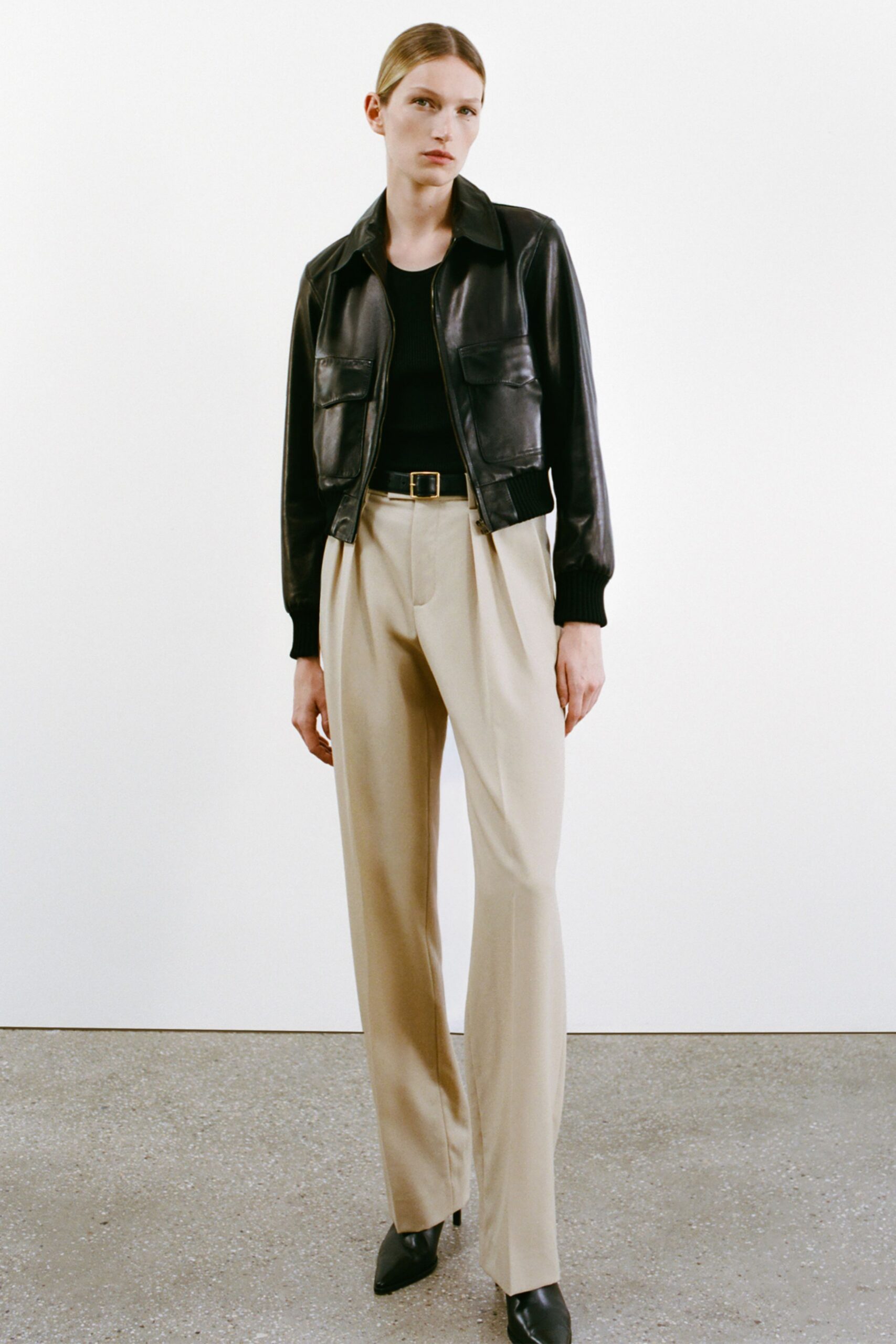 black leather jacket with beige pants