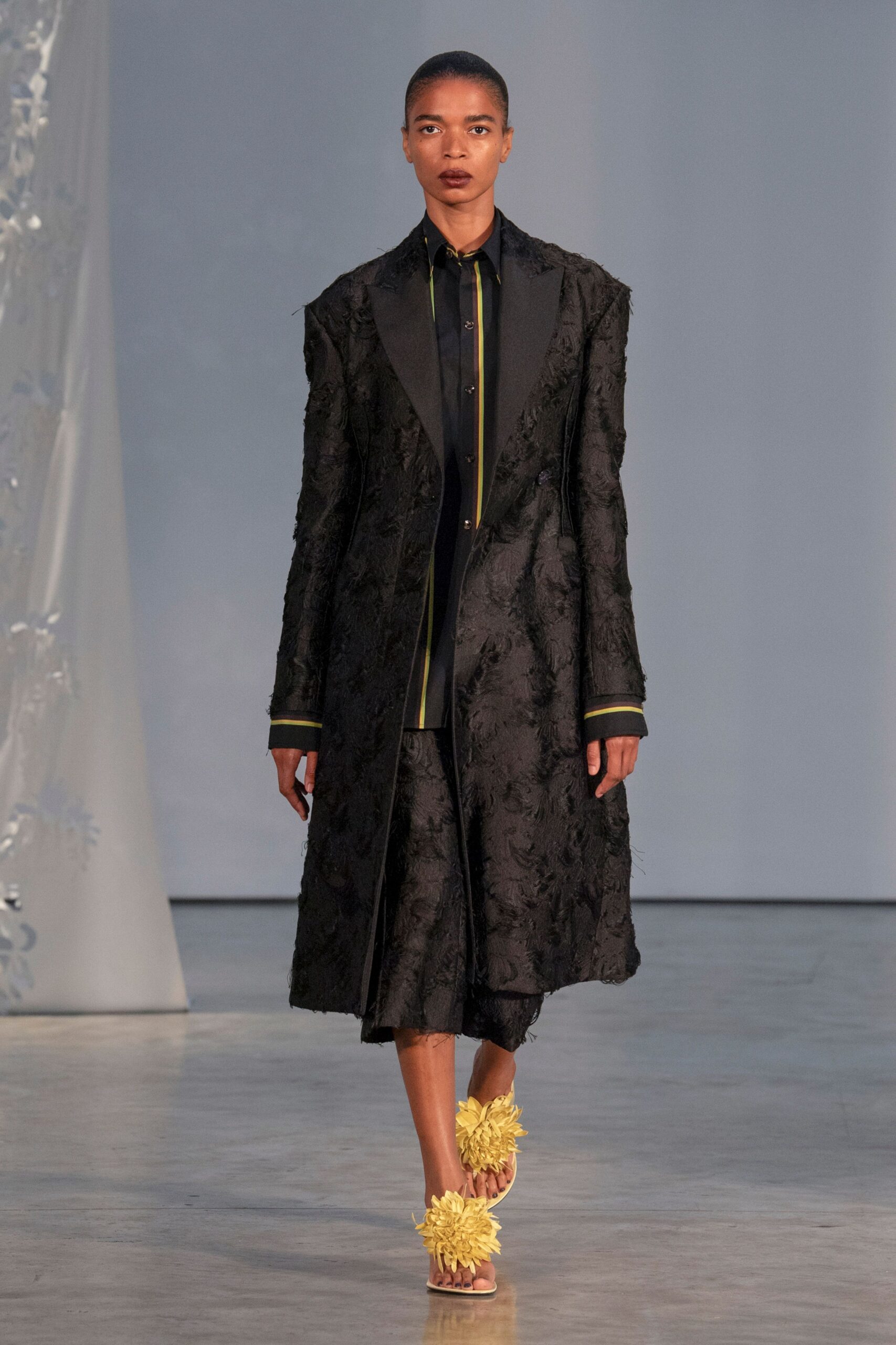 black embroidered coat with yellow shoes