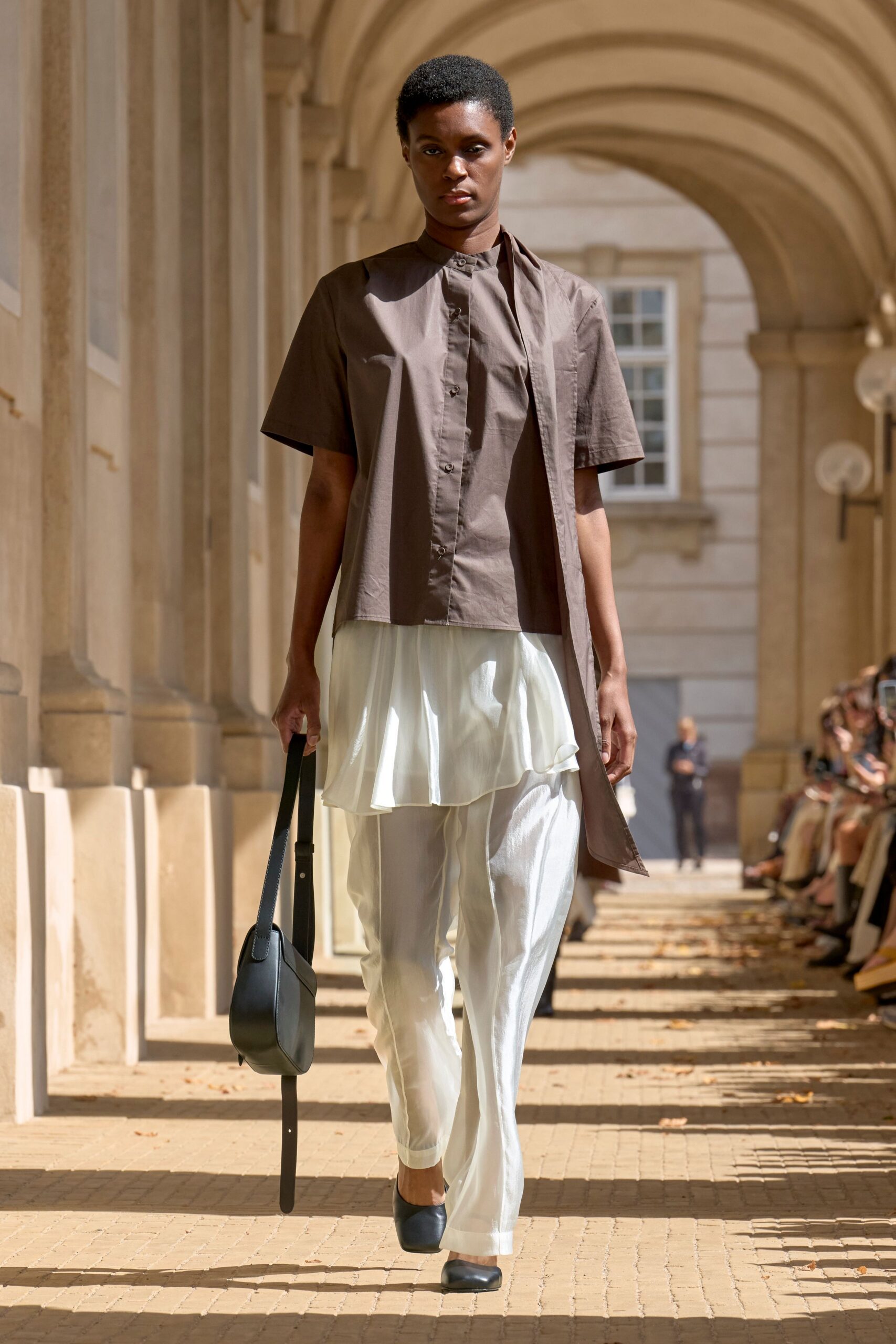 brown shirt white pants black accessories