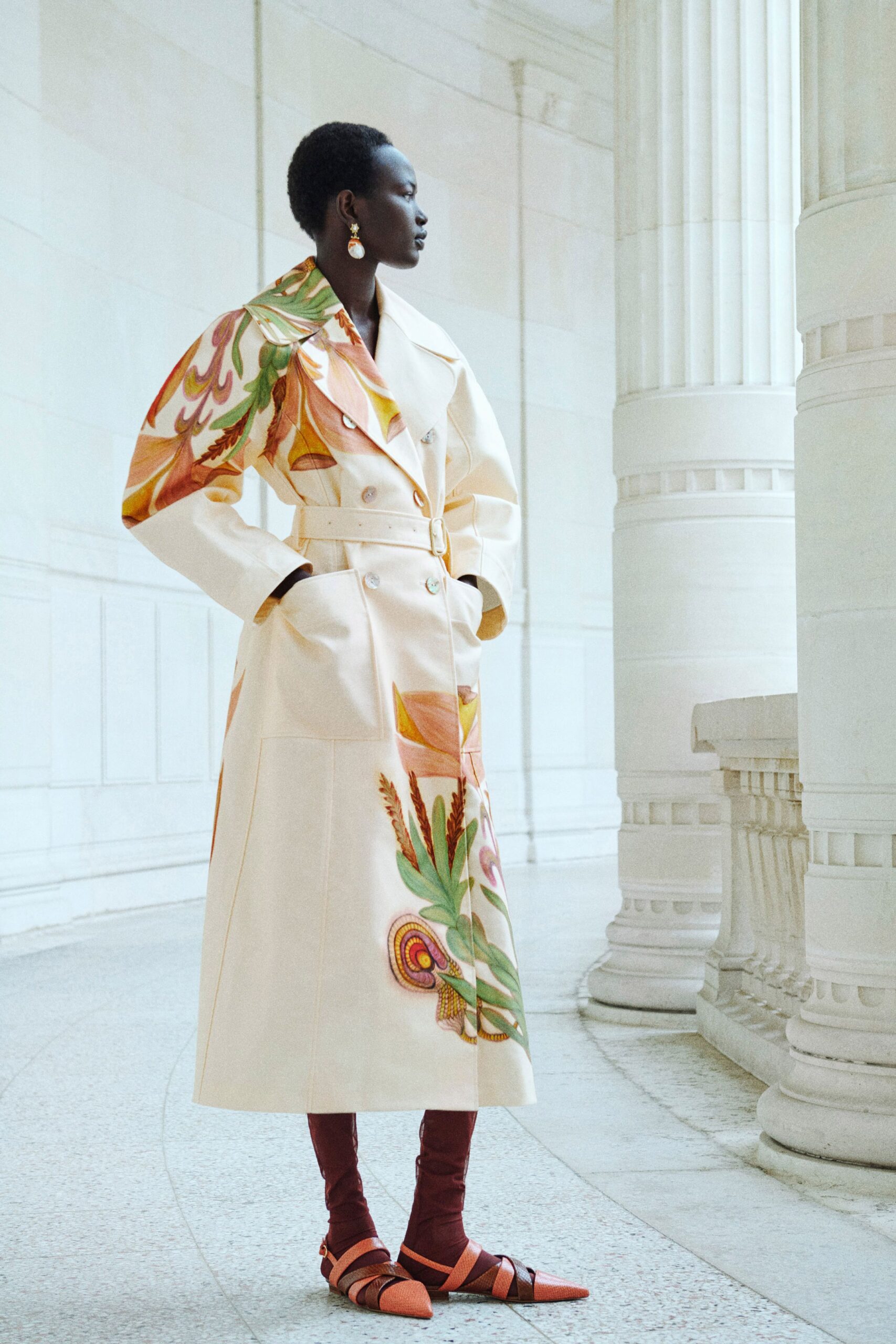 white printed trench coat and brown boots