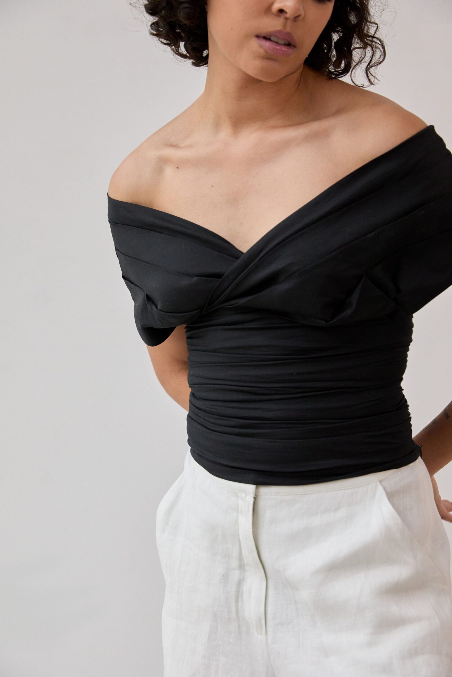 black off-shoulder top and white pants