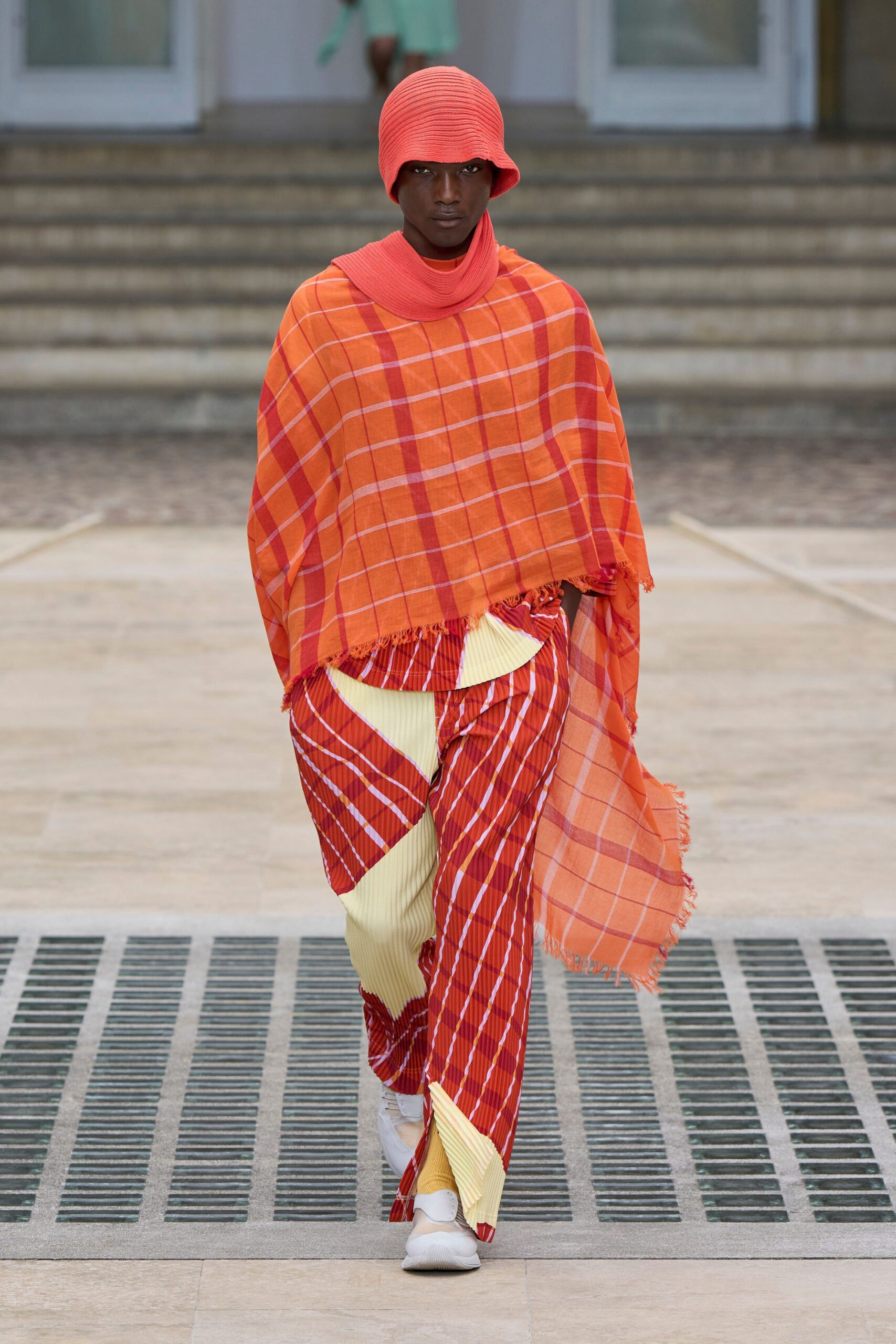 layered orange and red top with striped pants