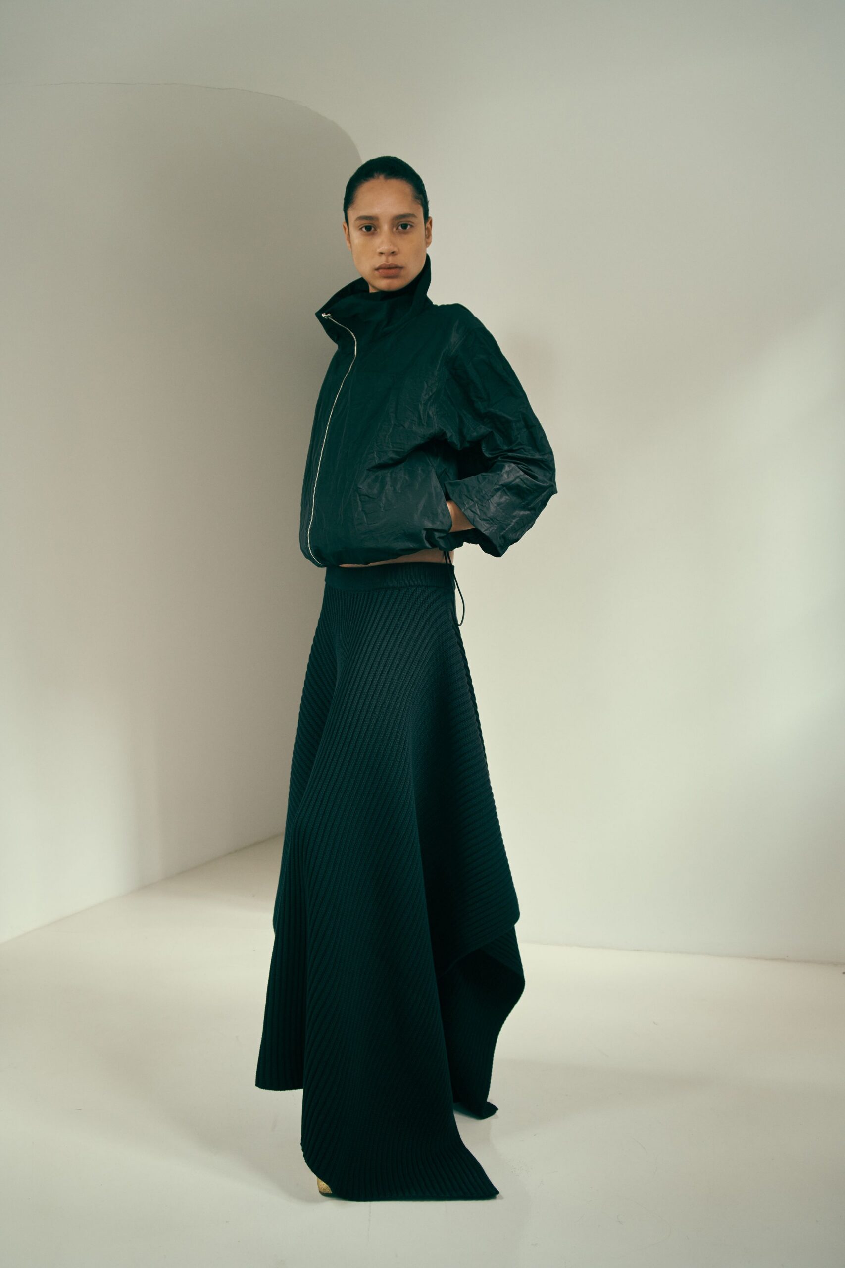 black vinyl jacket and pleated skirt