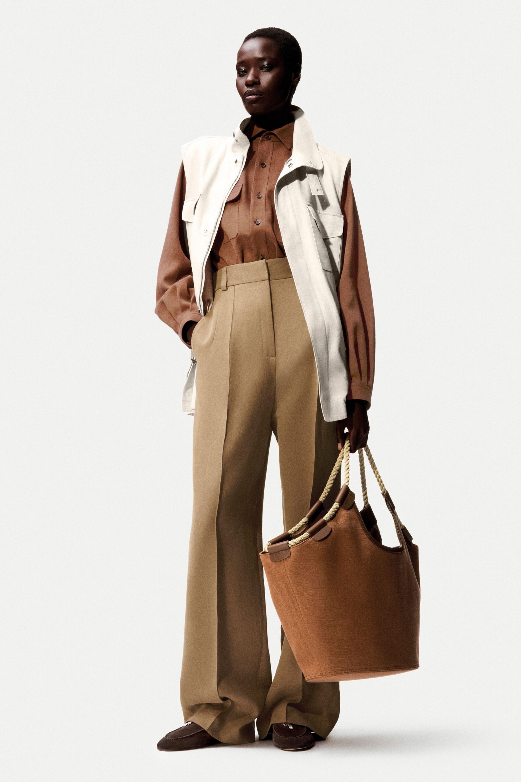 white vest brown shirt beige pants