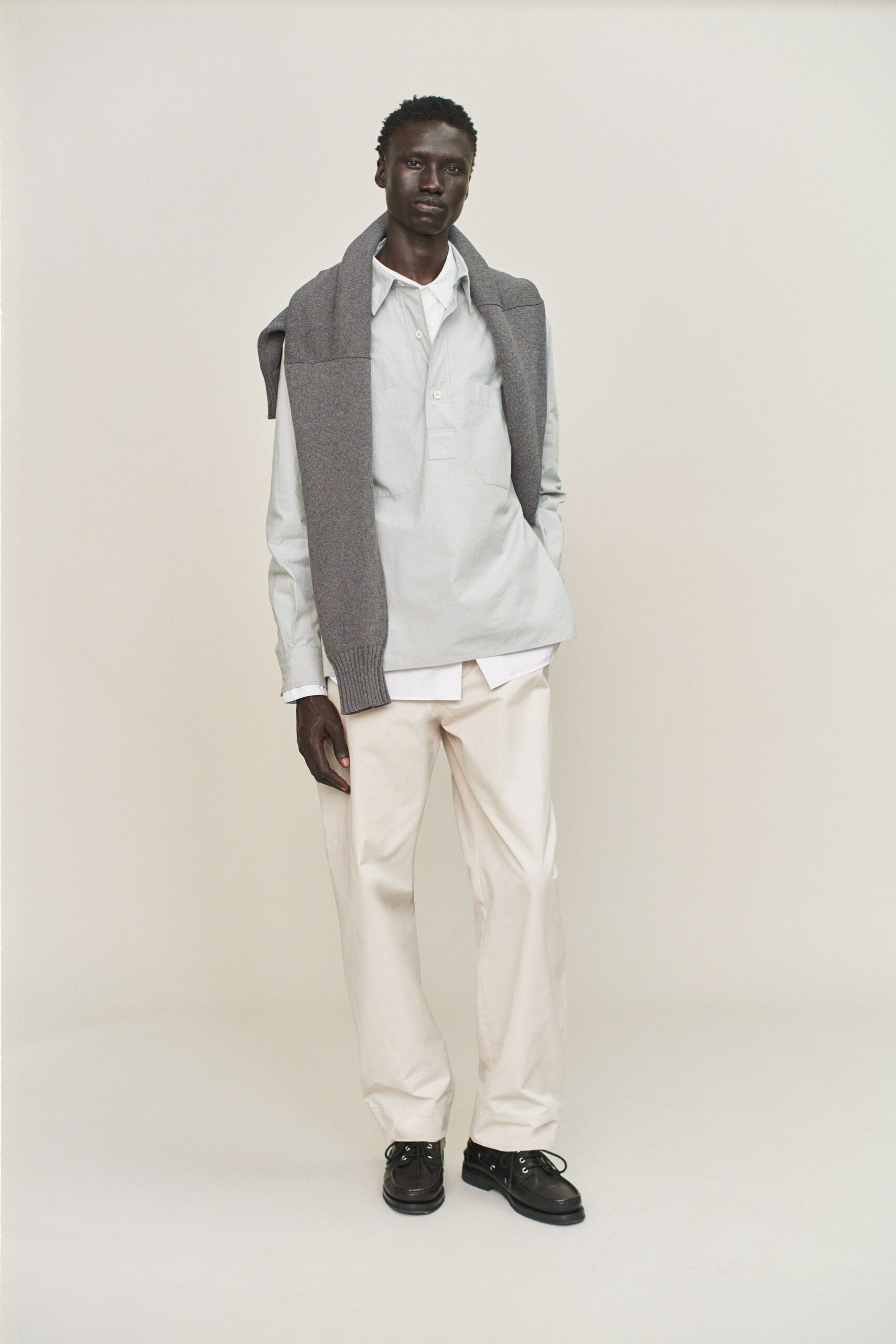 light blue shirt gray sweater beige pants