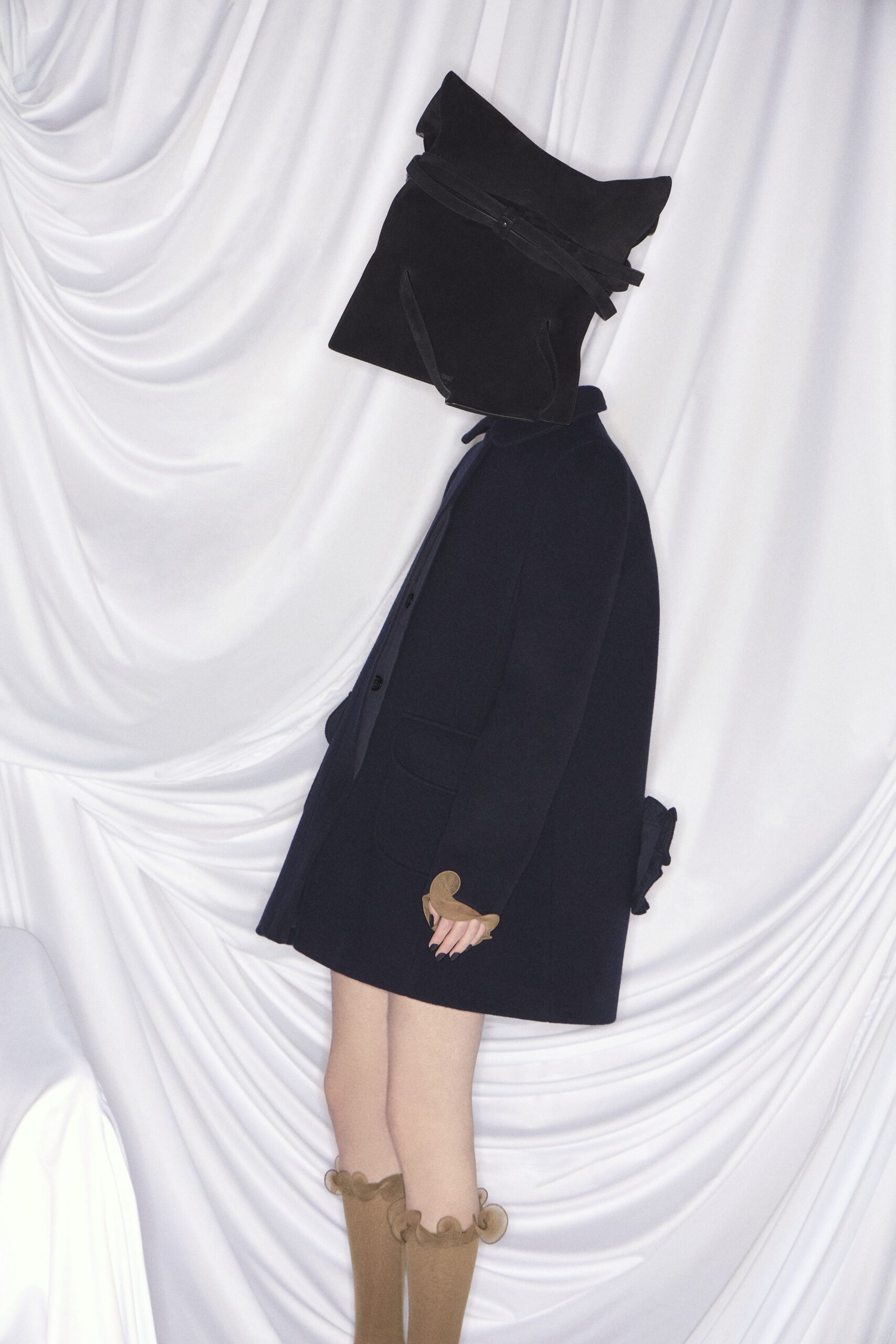 black wool coat with beige shorts