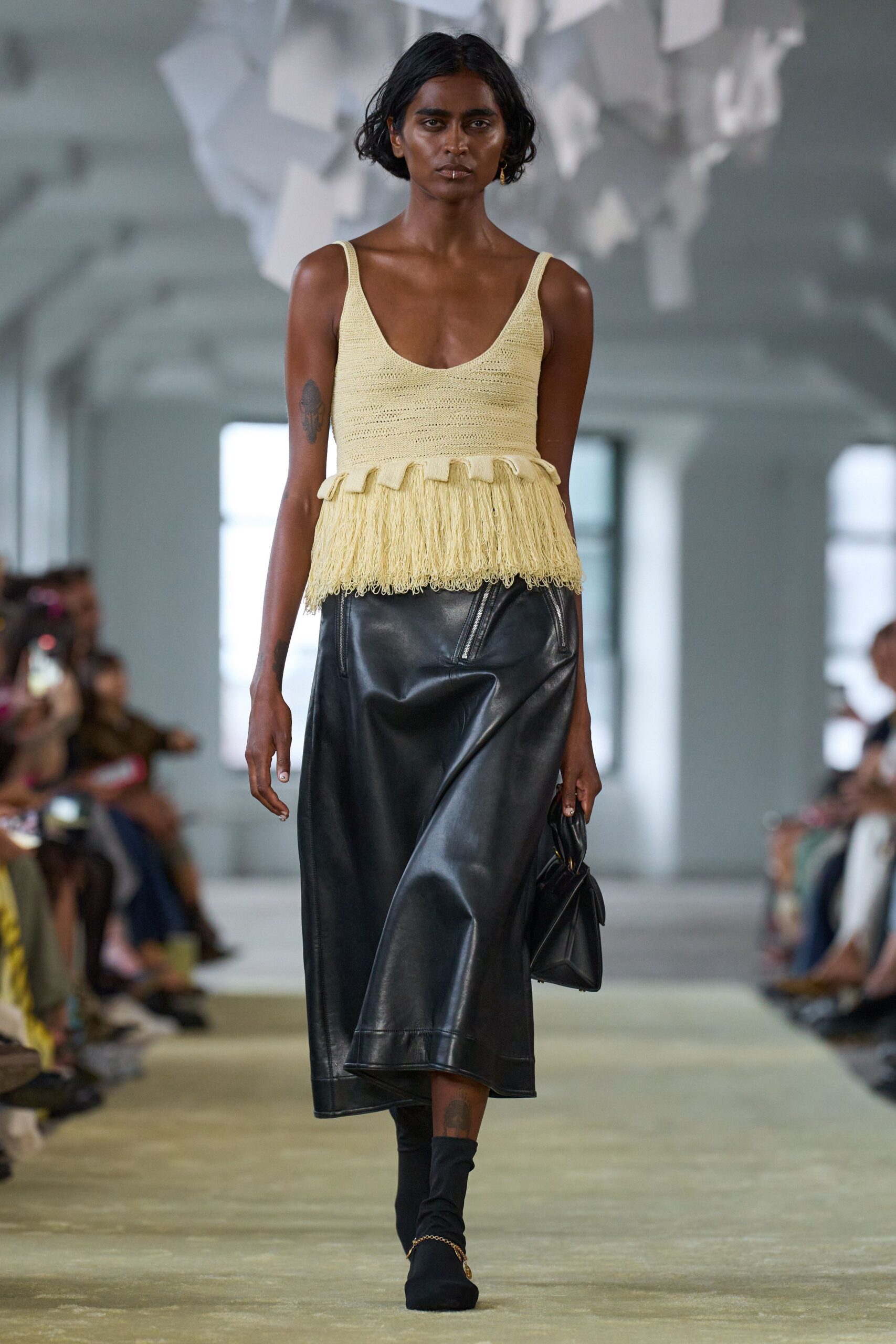 yellow fringed top with black skirt