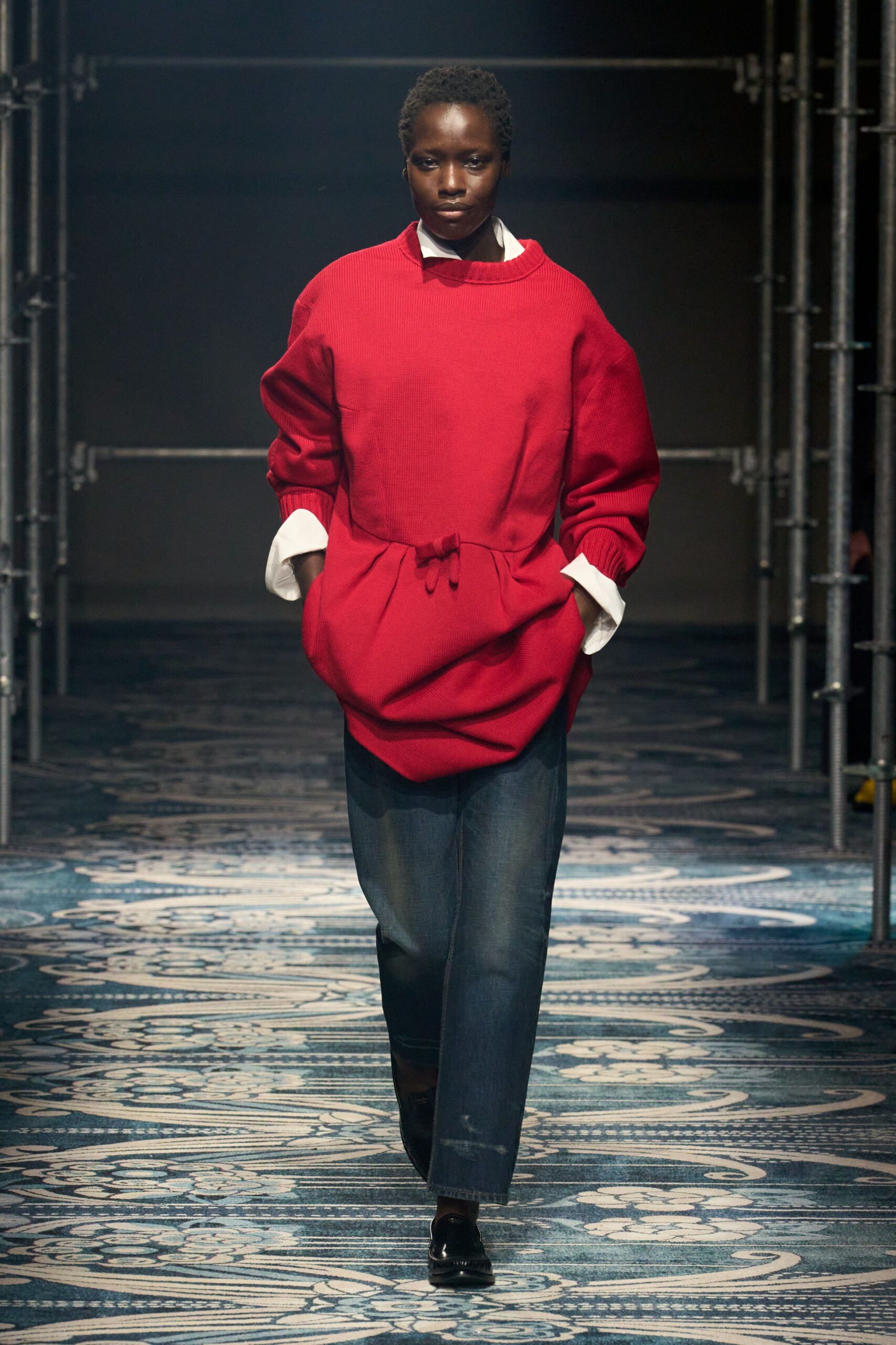 red relaxed sweater with blue jeans
