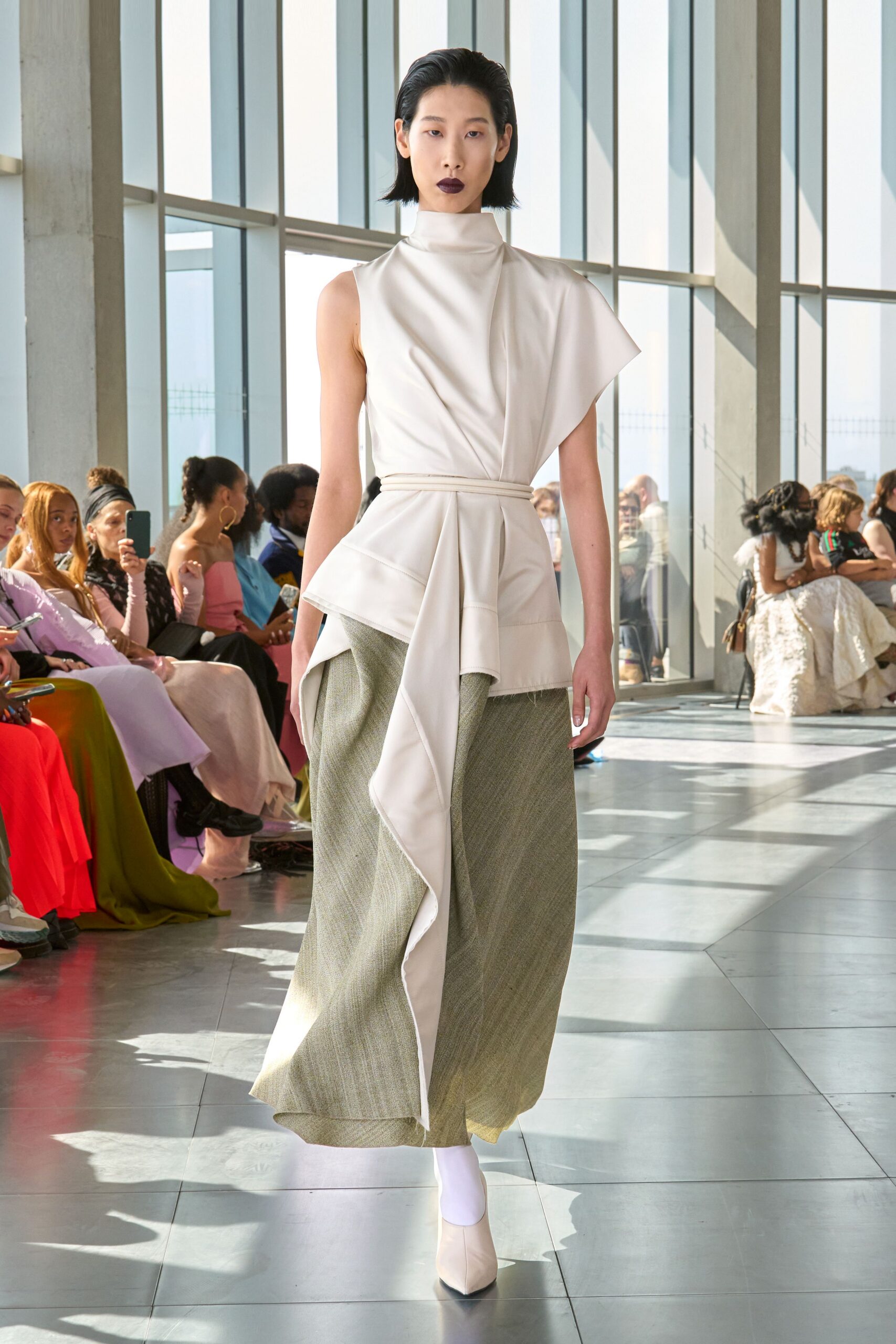 white silk asymmetric top with green pleated skirt
