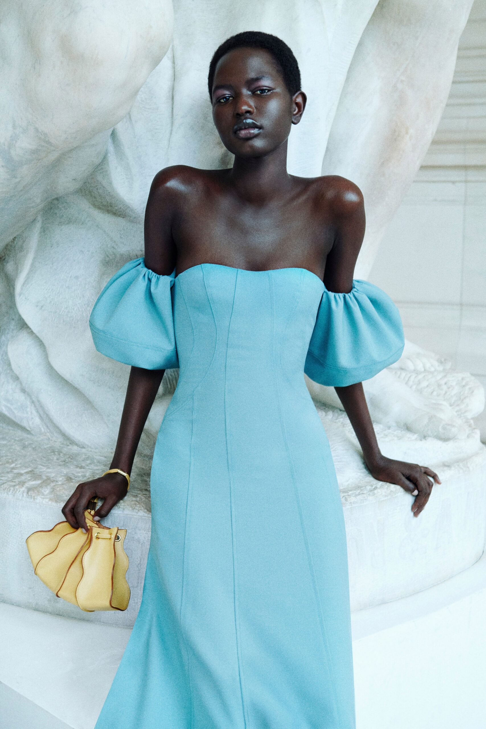 blue off-shoulder gown with yellow bag