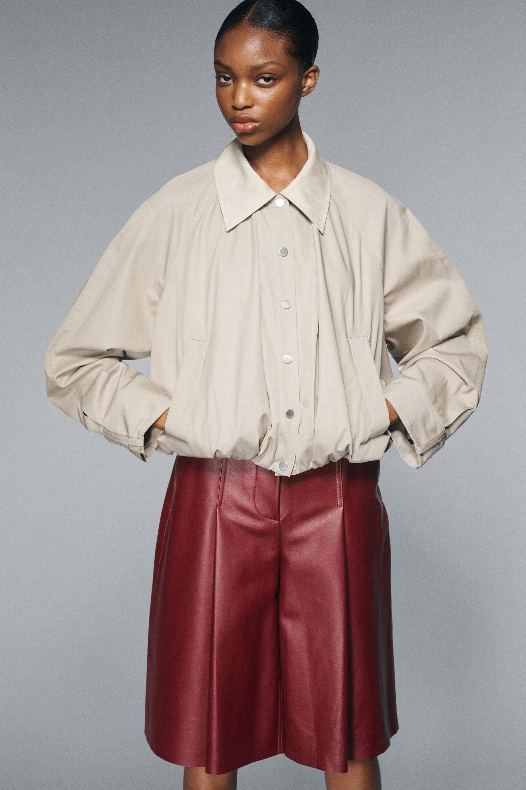 beige oversized shirt and red leather shorts
