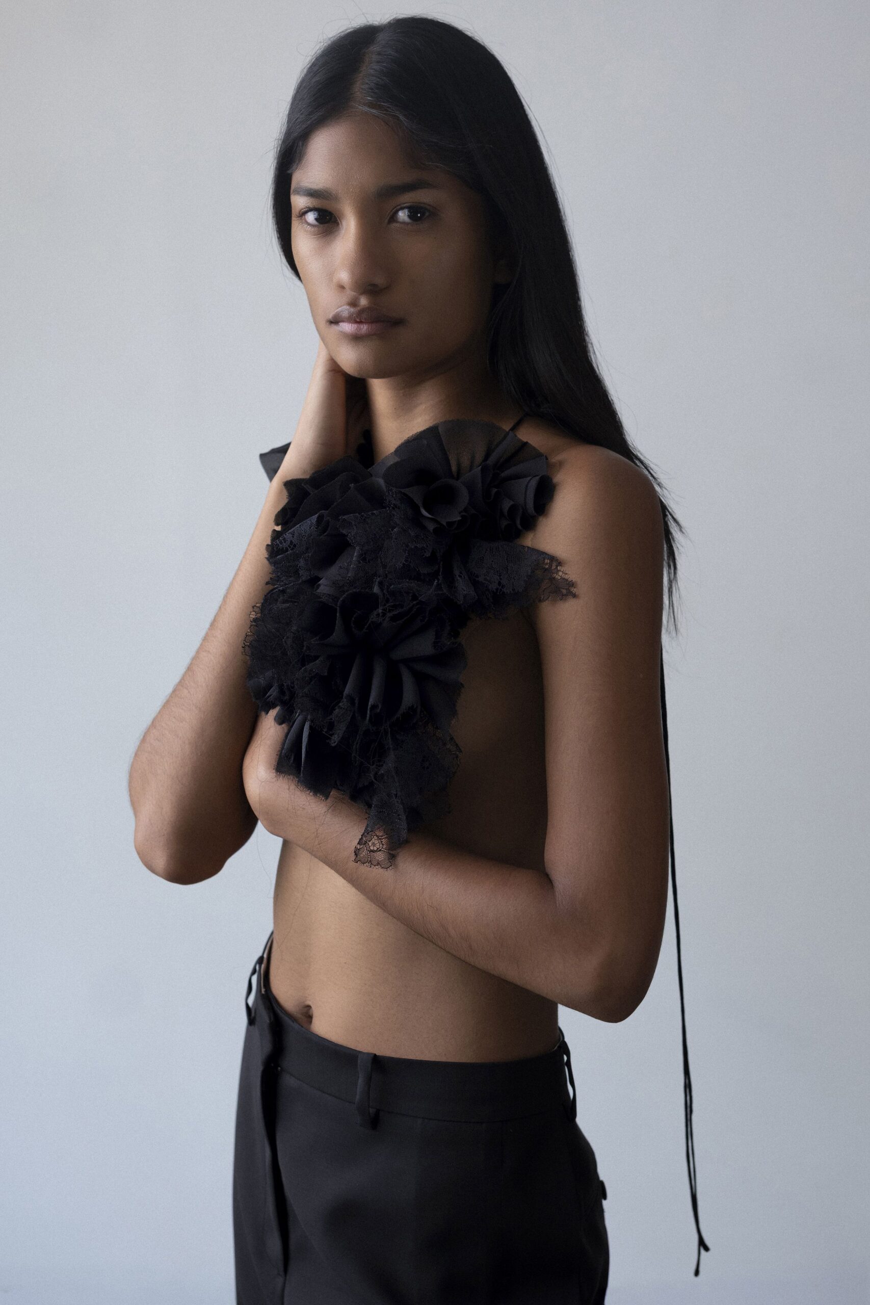 black ruffled top and tailored pants