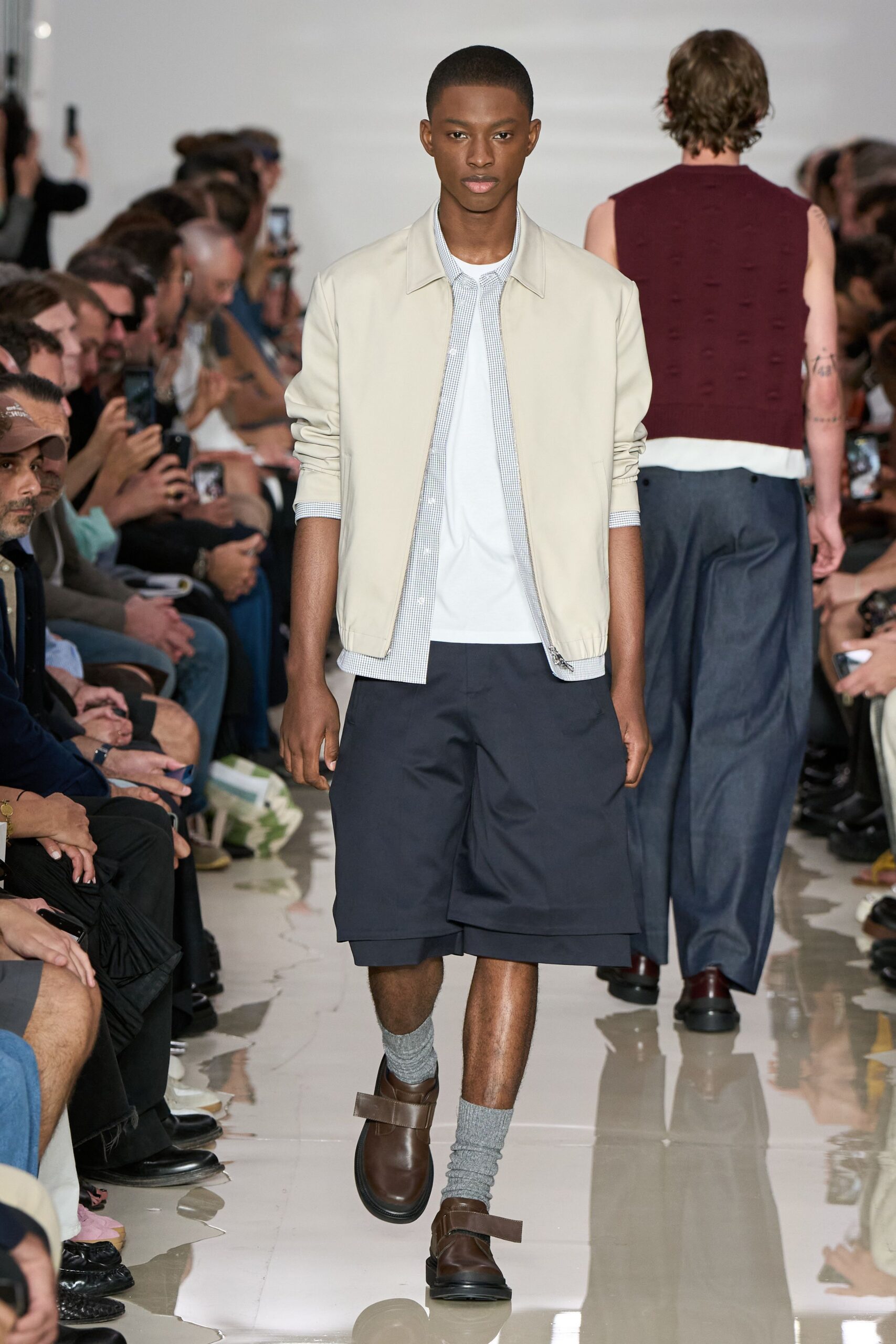 beige jacket white shirt navy shorts