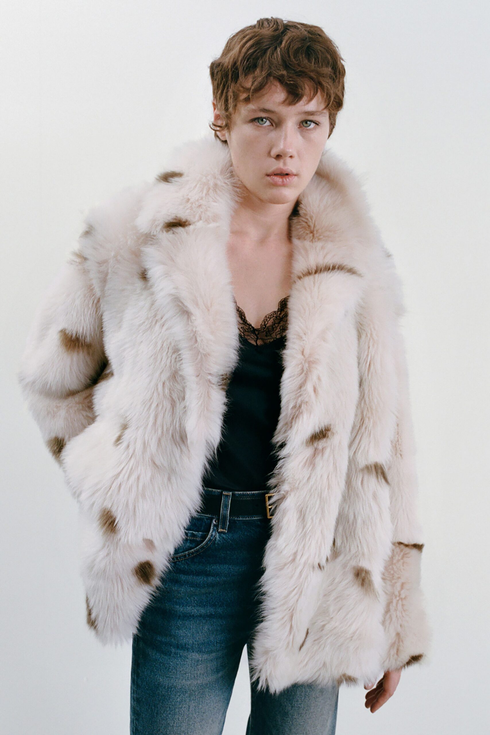 beige faux-fur coat with black top