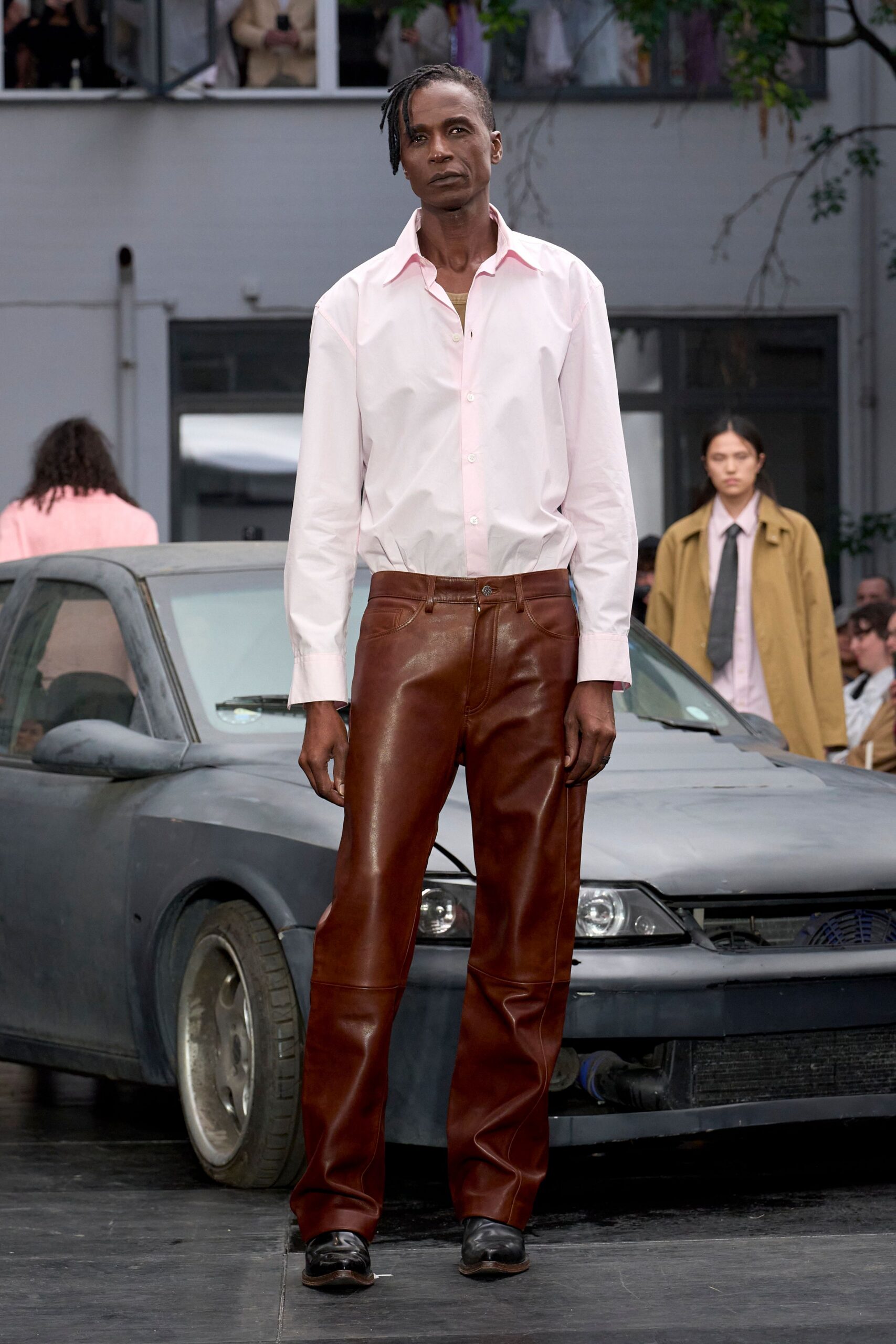 white pink collared shirt brown leather pants