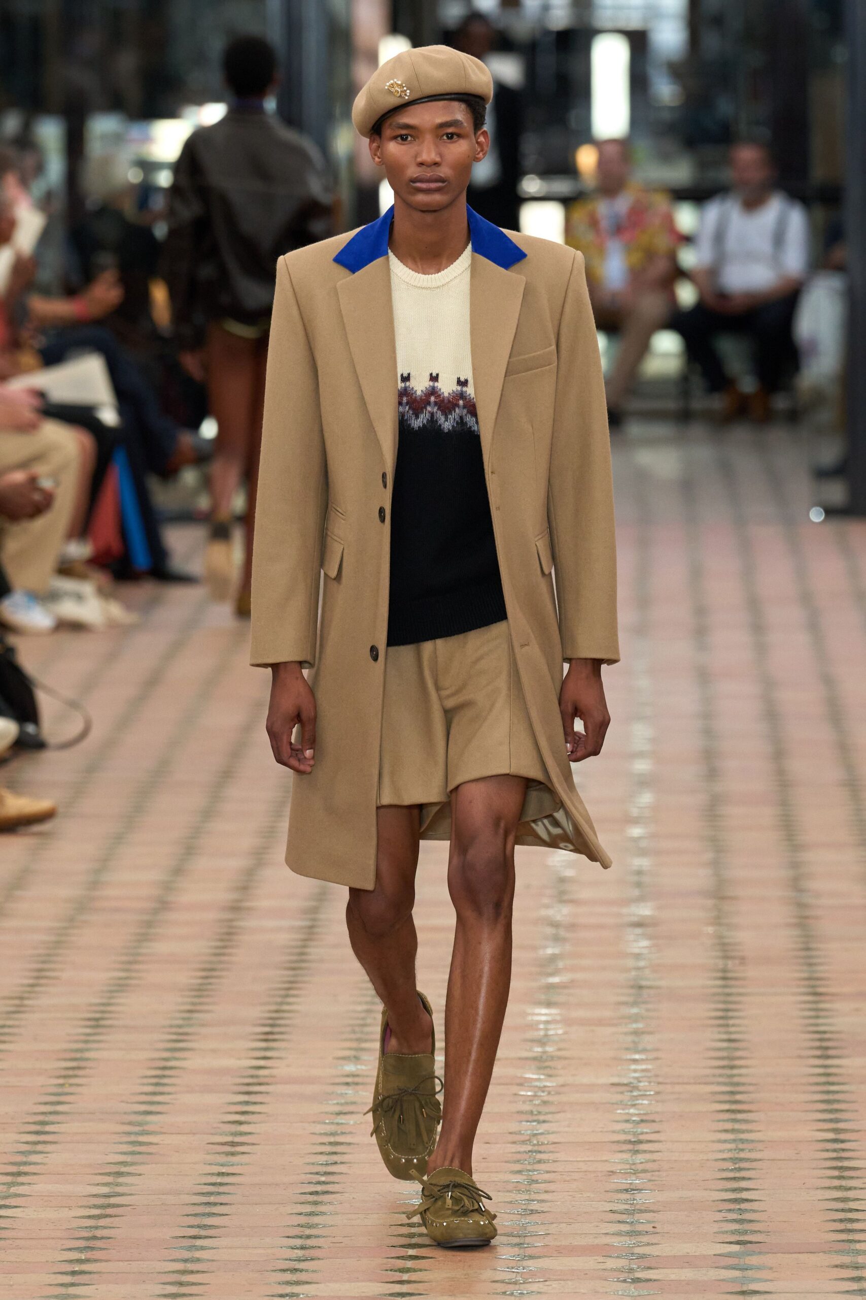 beige coat black sweater beige shorts