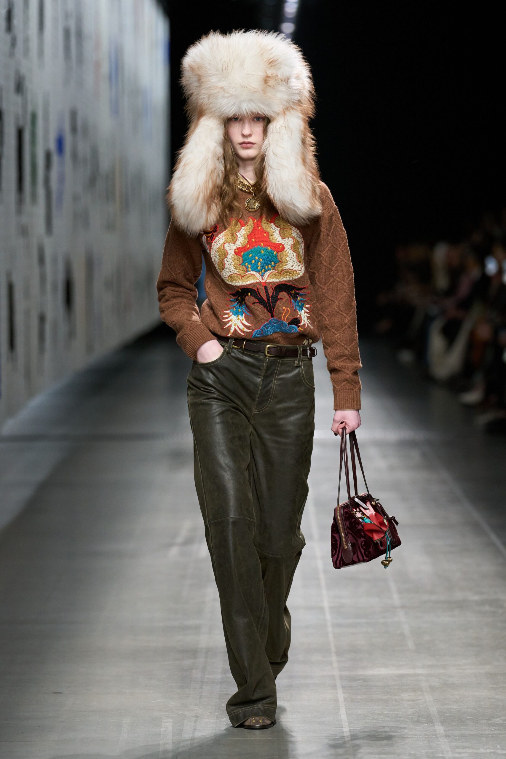 brown embroidered sweater with green pants