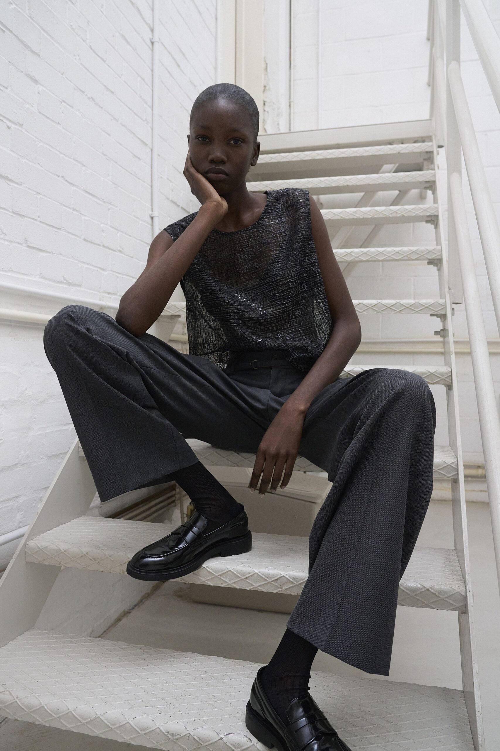 black sequined sleeveless top gray tailored pants